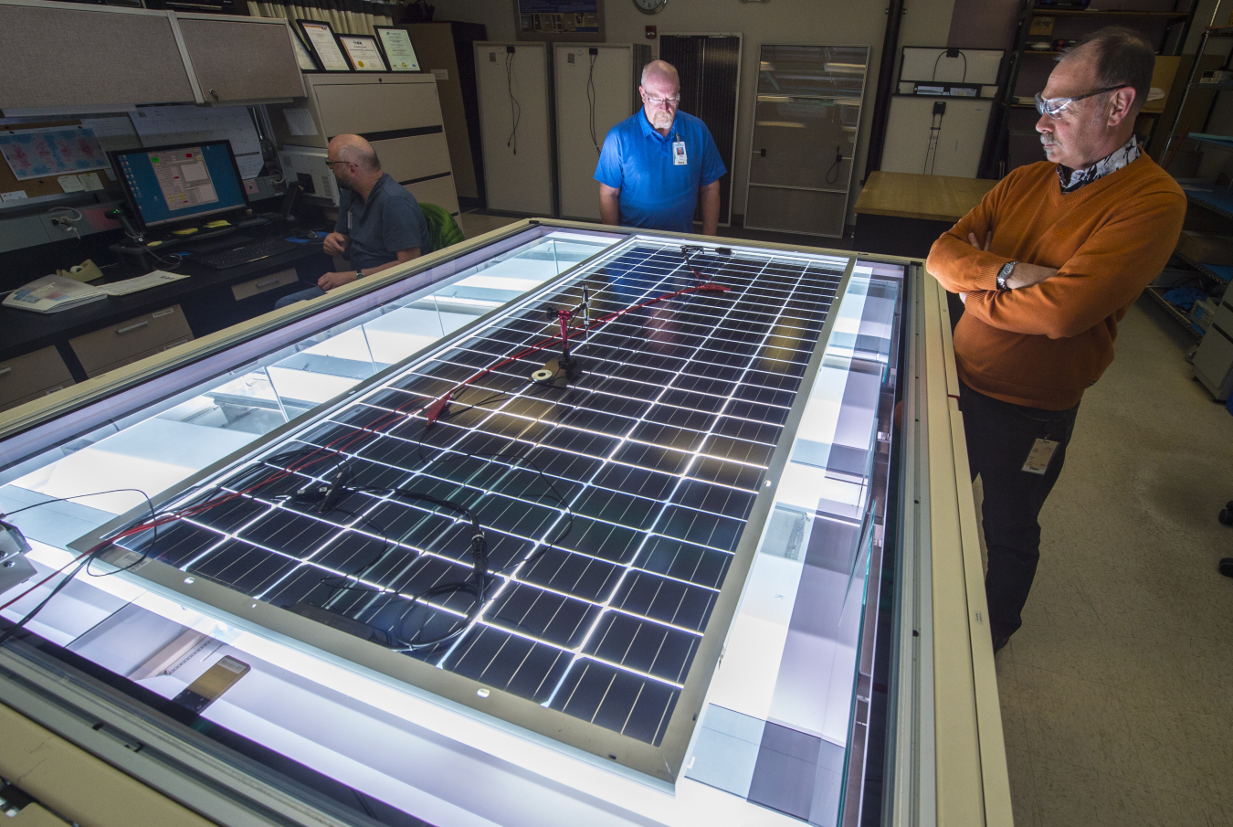 Allen Anderberg, Steve Rummel, and Dean Levi of NREL’s Cell and Module Performance group measure the power output of a PV module on NREL’s solar simulator. Photo by Dennis Schroeder.