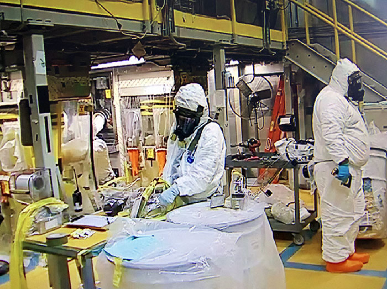 EM workers, donning required personal protective equipment, safely condition and repackage remaining waste in the Accelerated Retrieval Project V facility at DOE’s Idaho National Laboratory Site.