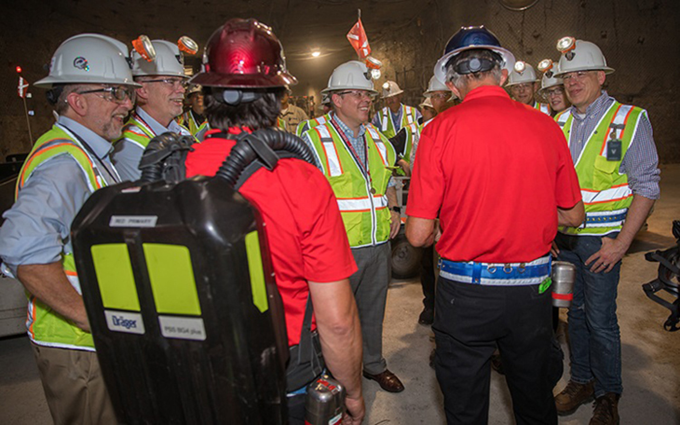 Ike White, center, Senior Advisor for EM, receives a briefing from members of the Waste Isolation Pilot Plant (WIPP) award-winning mine rescue teams as part of an underground tour at the WIPP site.