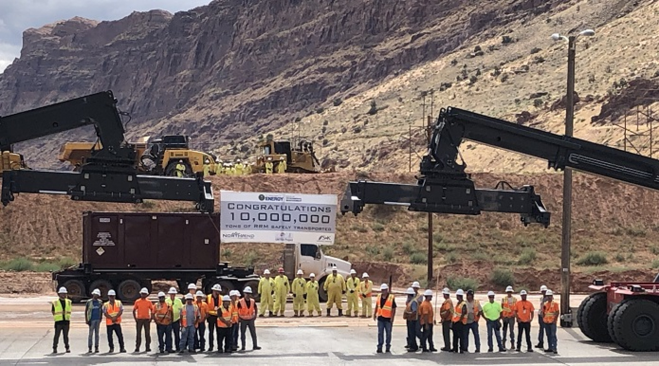 EM Moab Uranium Mill Tailings Remedial Action Project employees gather around project equipment after loading the 10 millionth ton of uranium mill tailings into a container to be shipped by train to the Crescent Junction disposal cell.