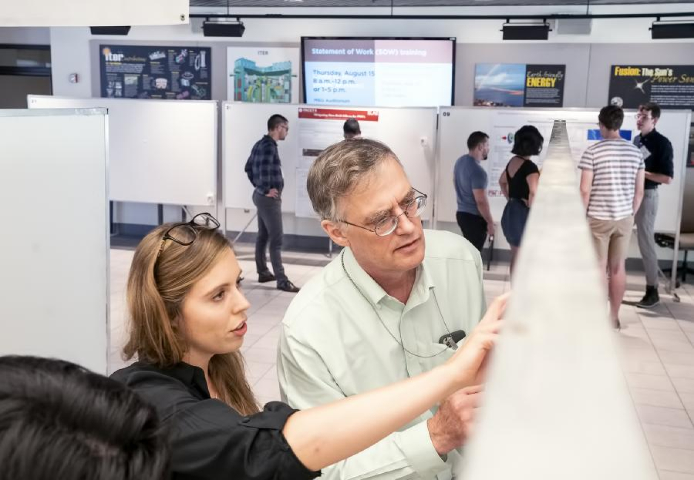 Physicist Eric Fredrickson looks at a student's poster during the poster session.