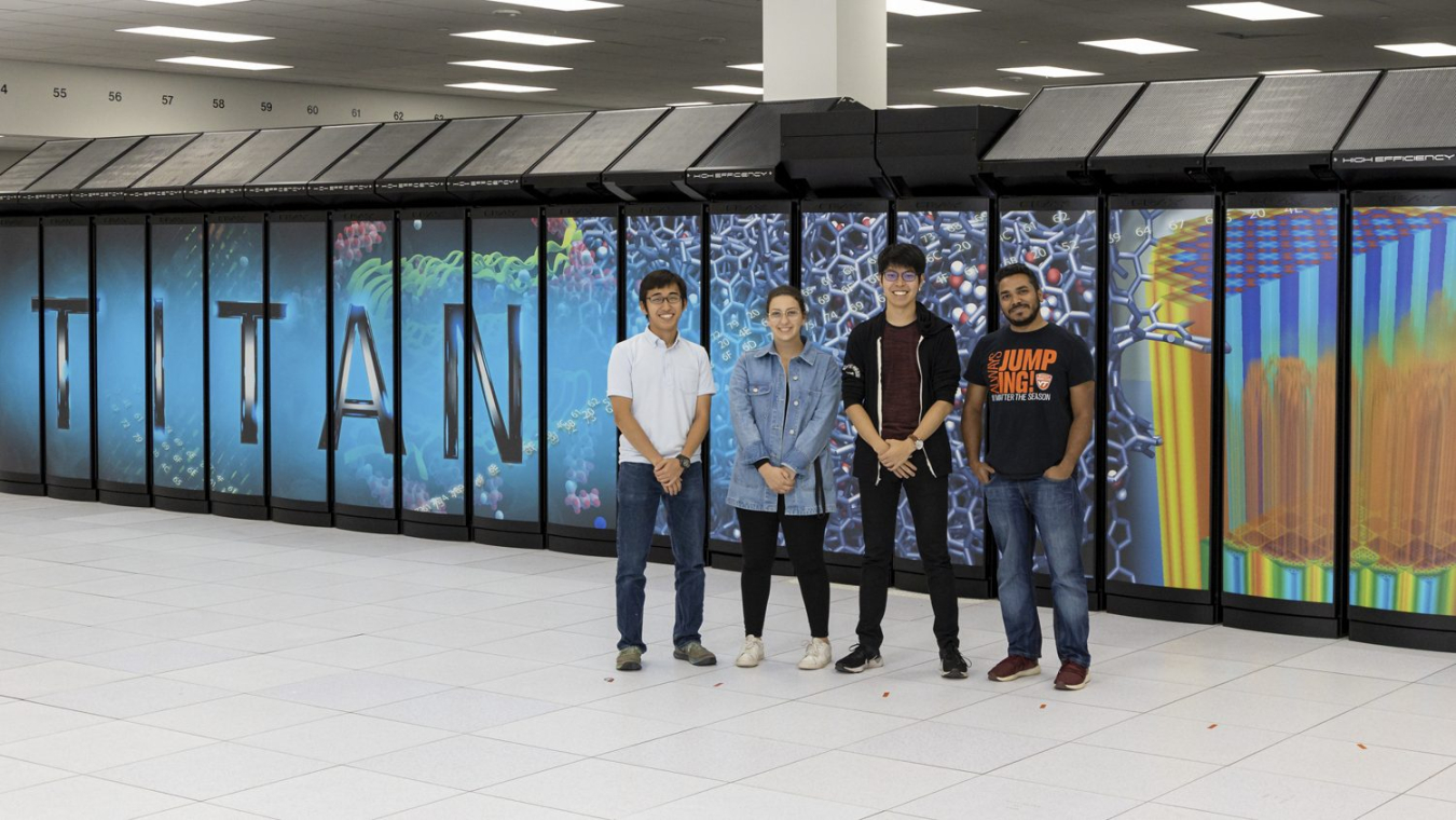 Four of the seven featured ADW 2019 interns are shown in front of Titan (left to right): Shuto Araki, Emily Costa, Yuya Kawakami, and Sajal Dash.