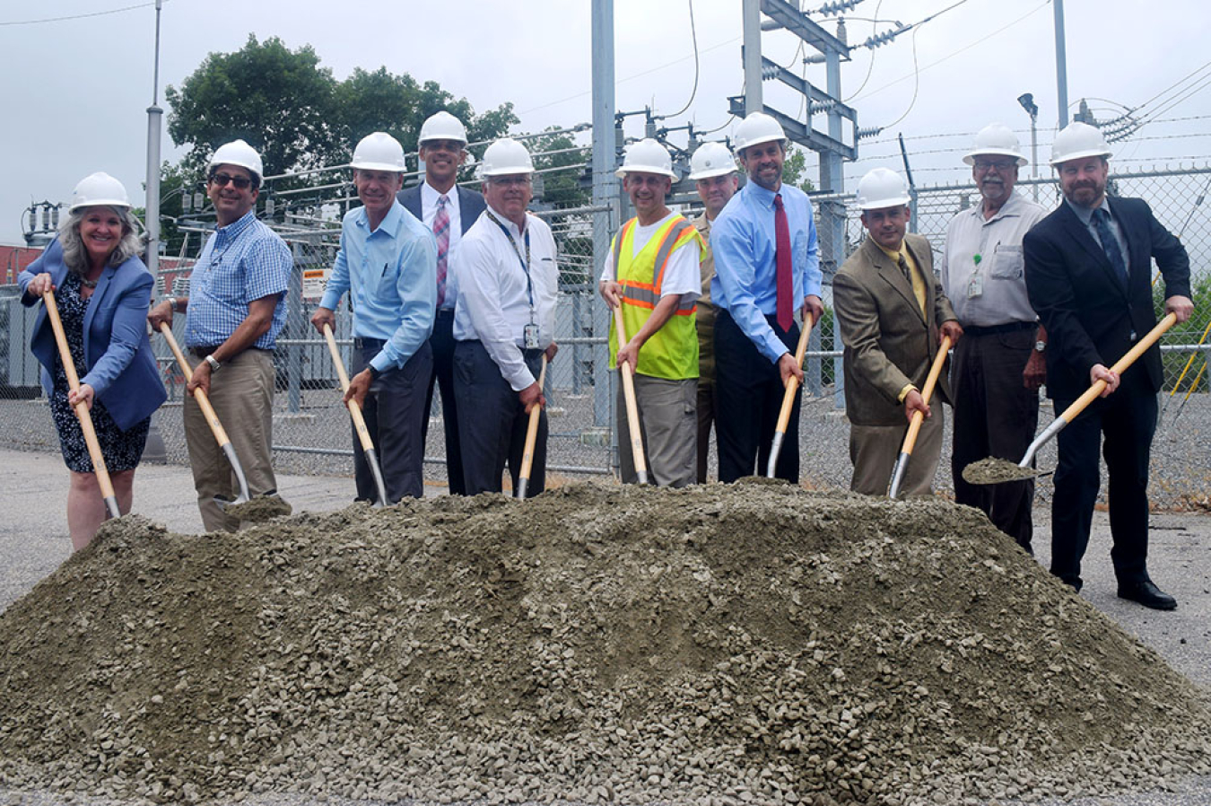 11 people with shovels breaking ground.