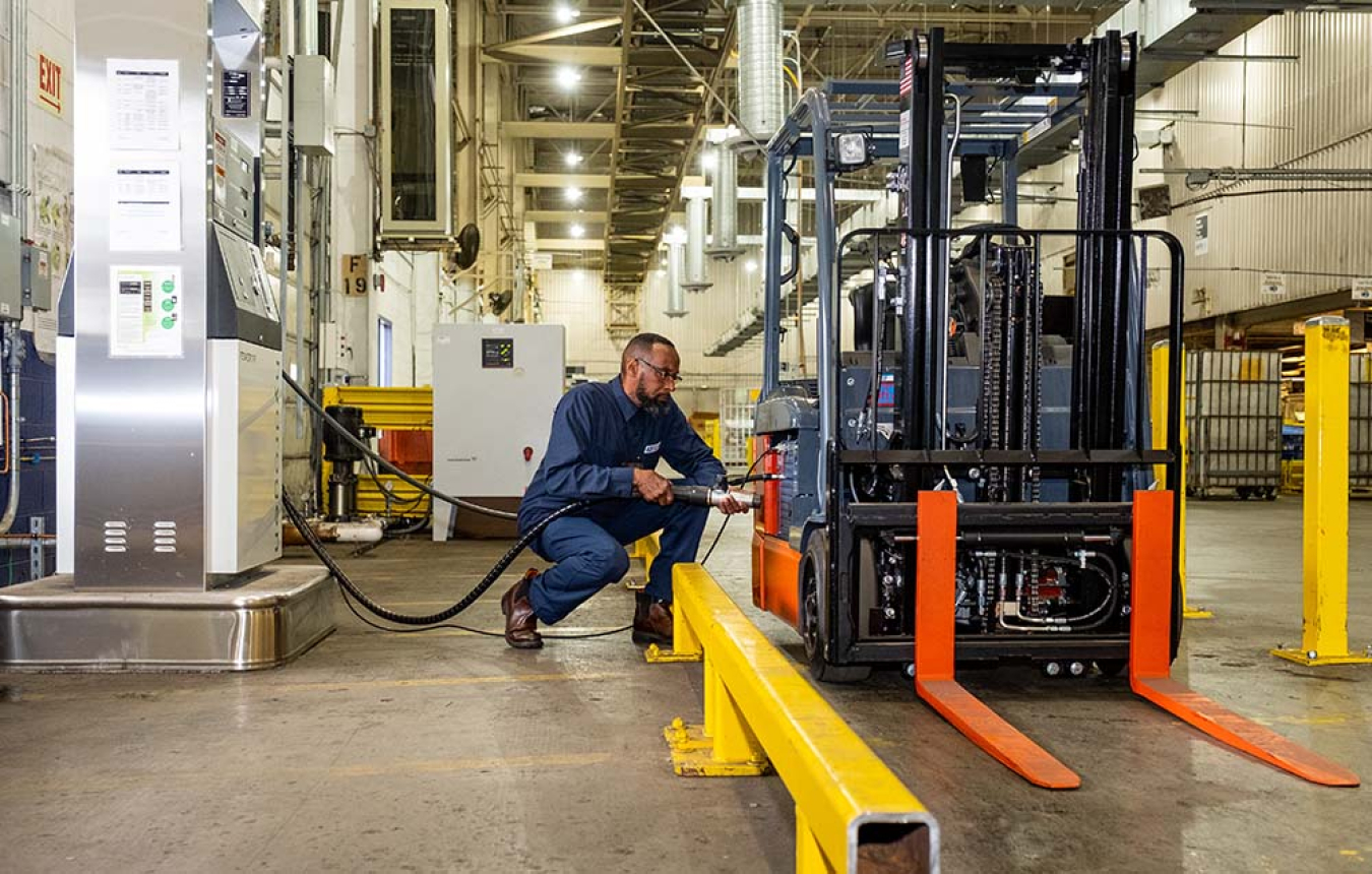 A person fueling a forklift.