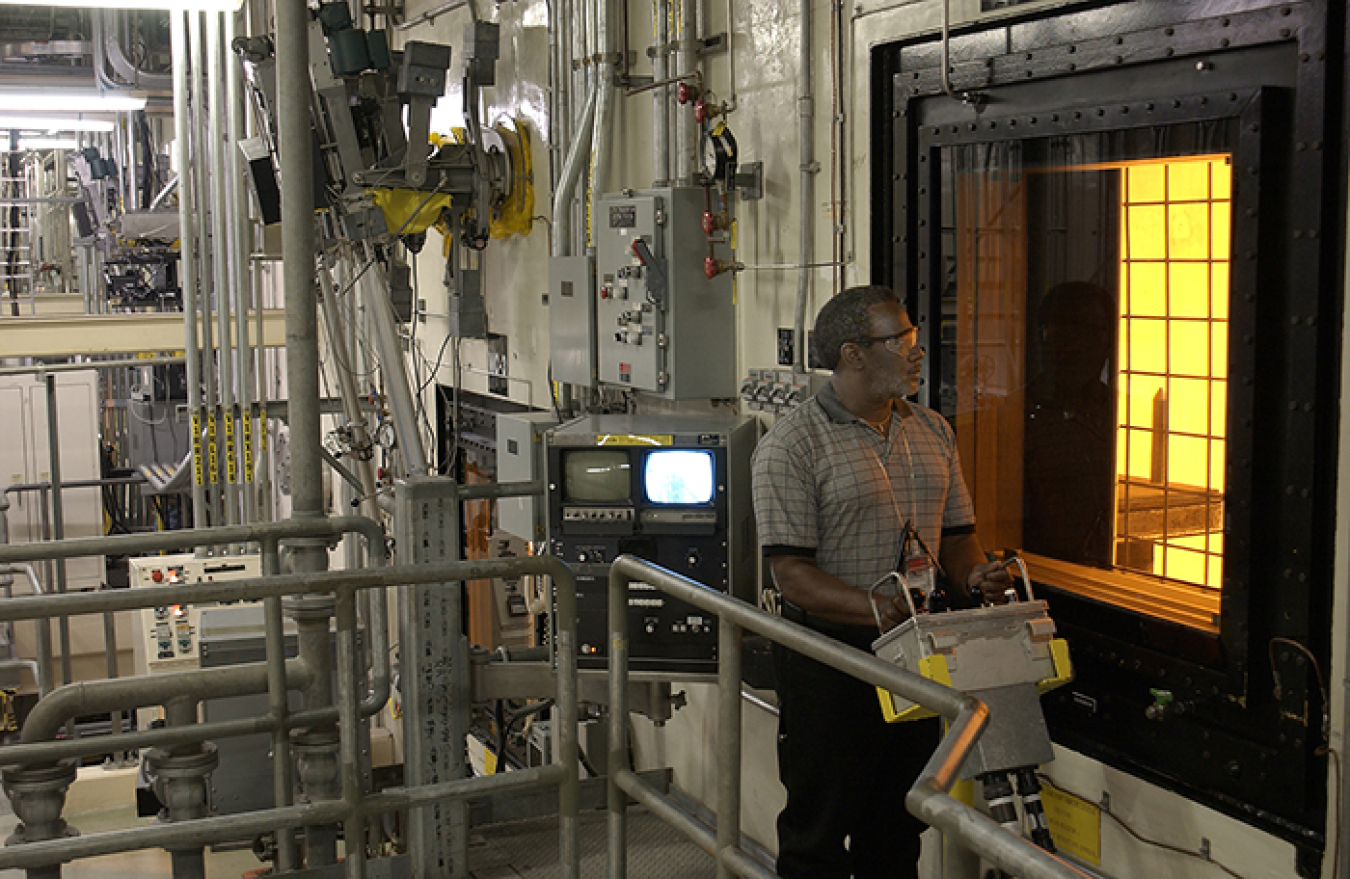 An operator at the Defense Waste Processing Facility maneuvers a canister inside the DWPF canyon via remote controls. All radioactive operations inside DWPF are conducted remotely.