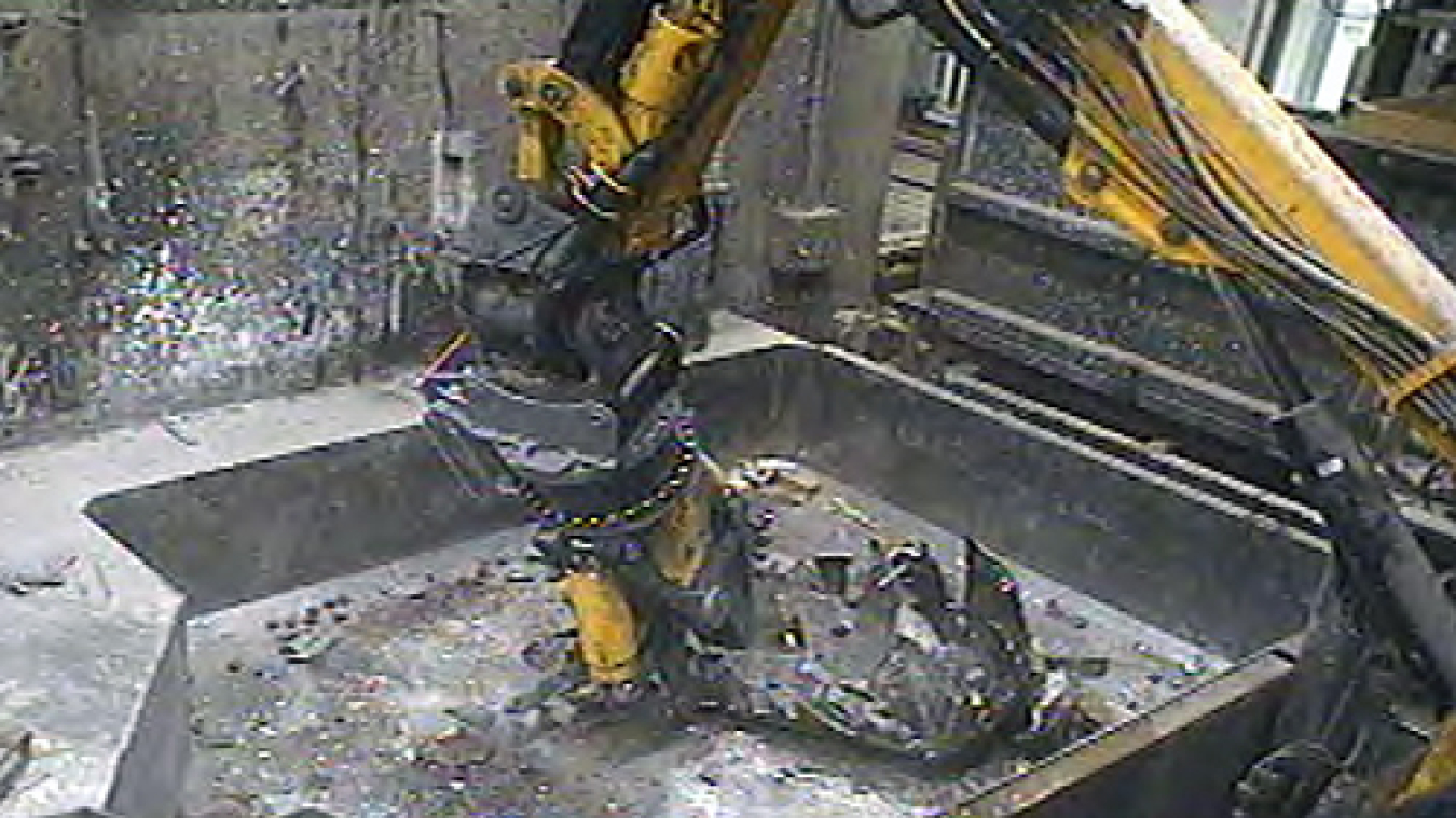 A robotic arm resizes a metal tank in one of the Advanced Mixed Waste Treatment Project’s boxlines.