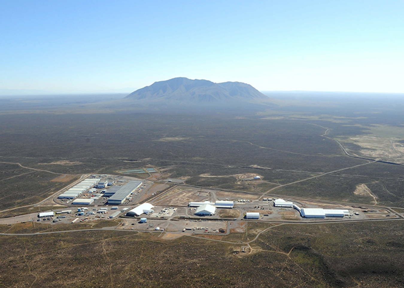 At top is a view of the Radioactive Waste Management Complex at DOE's Idaho National Laboratory Site. Ultimately, an earthen cover will be built over the site as shown in the rendering immediately above.