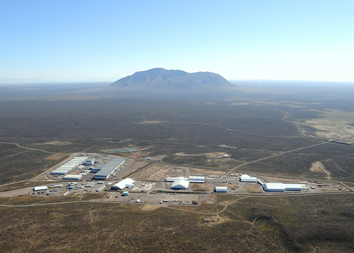 At top is a view of the Radioactive Waste Management Complex at DOE's Idaho National Laboratory Site. Ultimately, an earthen cover will be built over the site as shown in the rendering immediately above. 