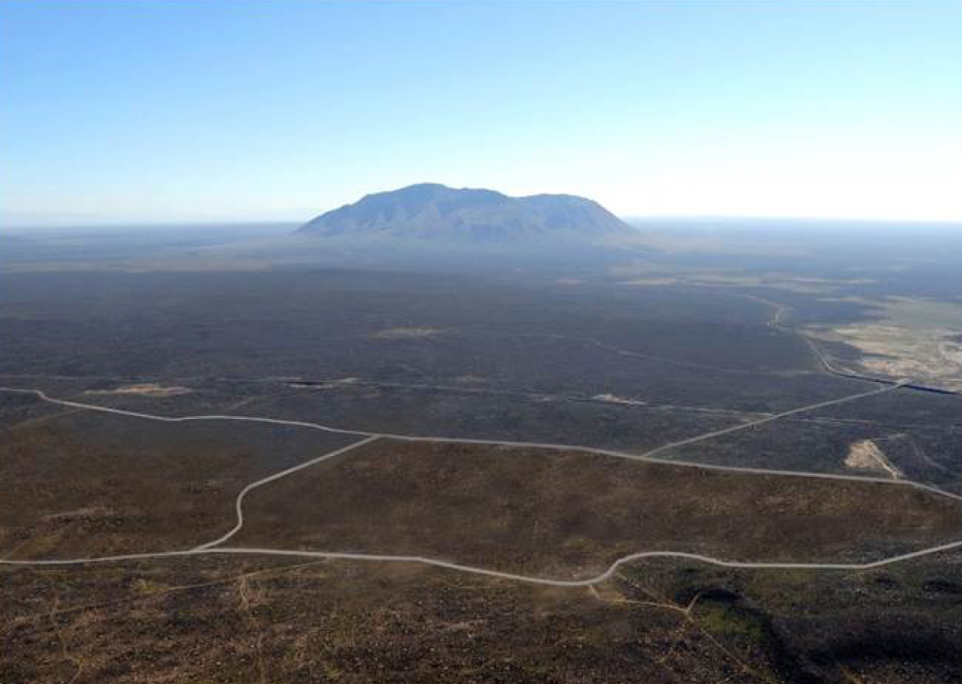 At top is a view of the Radioactive Waste Management Complex at DOE's Idaho National Laboratory Site. Ultimately, an earthen cover will be built over the site as shown in the rendering immediately above. 