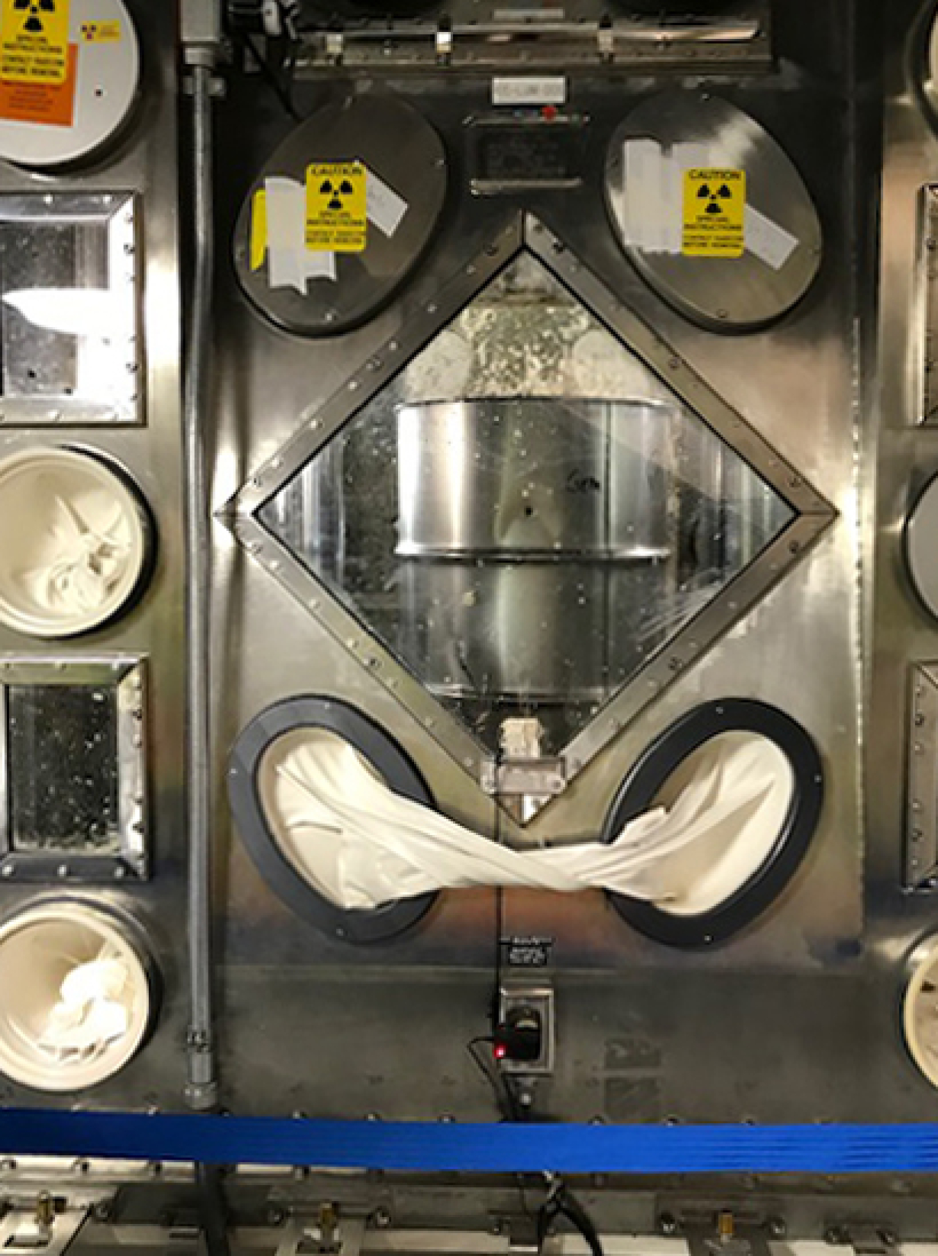 A waste drum awaits the supercompactor's hydraulic ram.