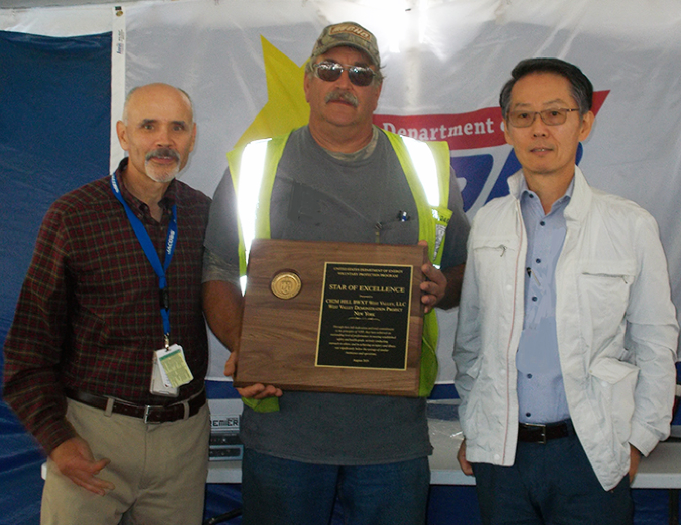 Dae Chung, far right, EM Deputy Assistant Secretary for Safety, Security, and Quality Assurance, presents the DOE Voluntary Protection Program Star of Excellence award to John Rendall.
