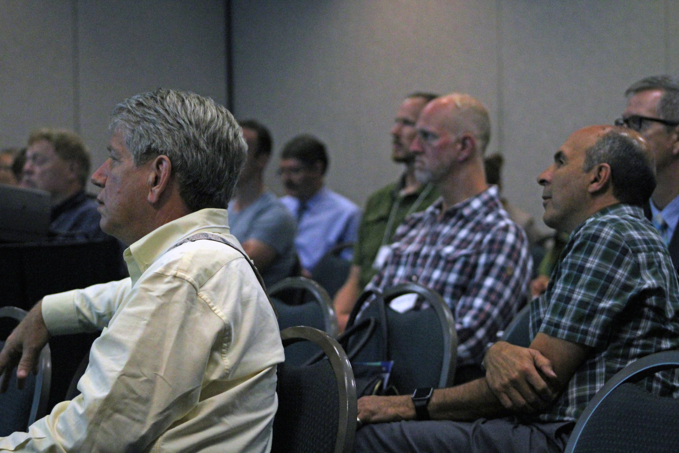 Audience members listen to a presentation.