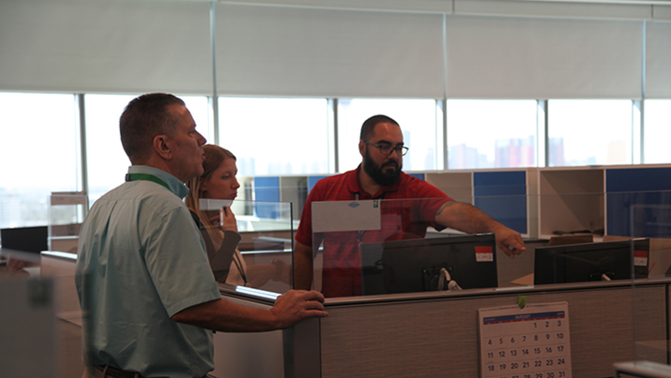 From left, Ray Mele, Kelly Pavelka, and David Mendez, all employees with EM Nevada Program contractor Navarro, discuss the logistics of the program's relocation to new offices in Las Vegas.