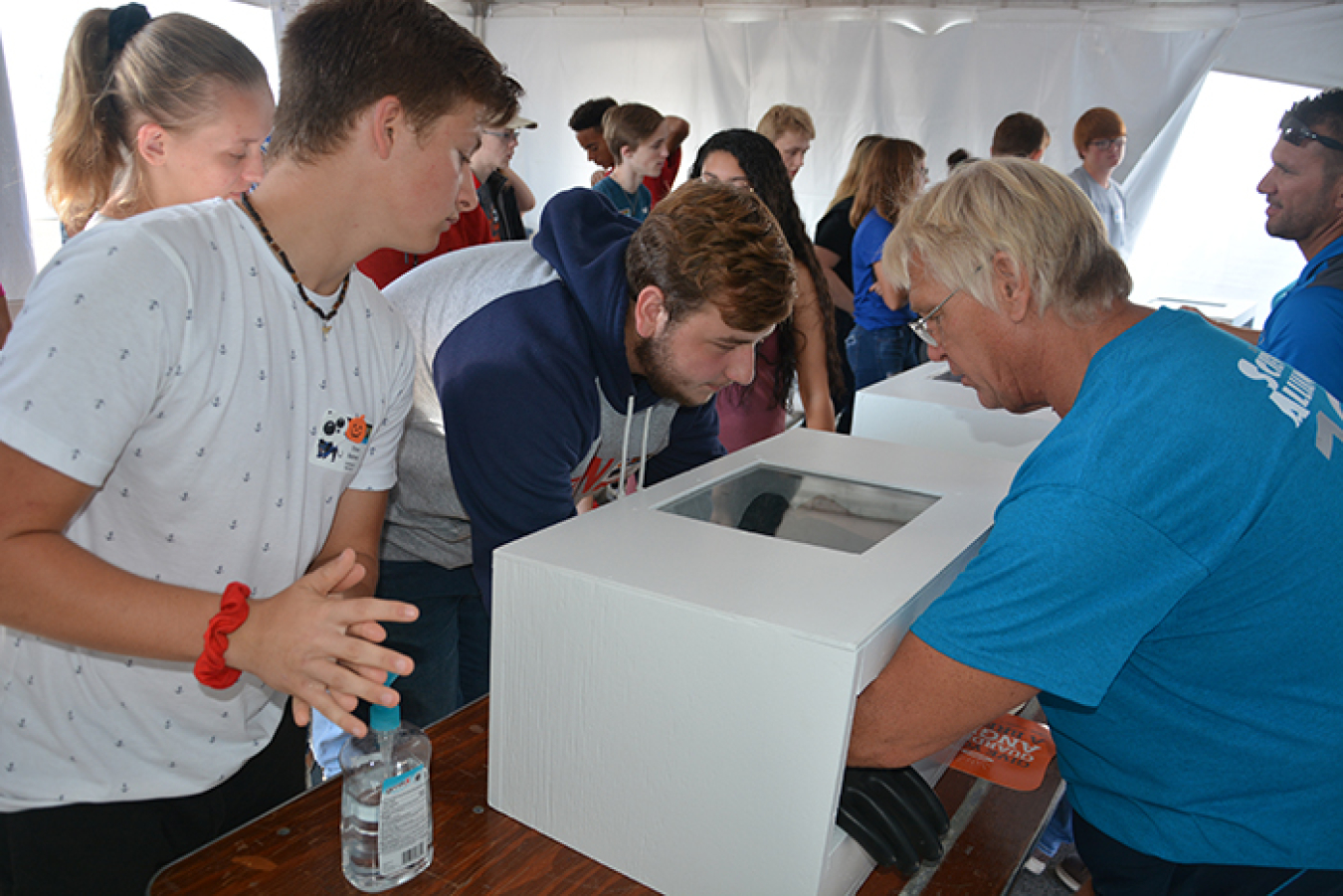 Dan Minter with EM contractor Portsmouth Mission Alliance, right, works with students during a glovebox demonstration at EM’s Science Alliance event.