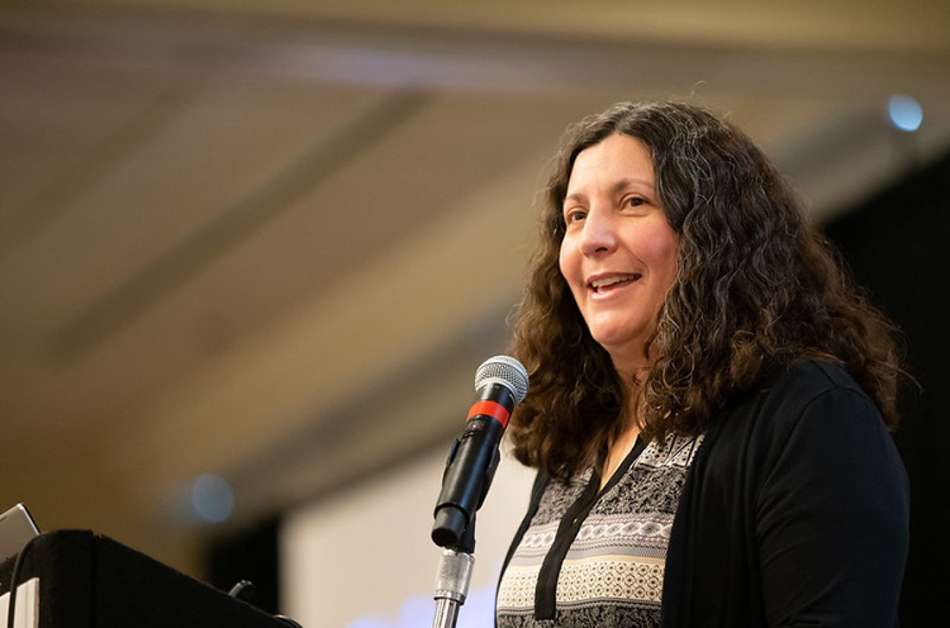 Woman at a podium at the Program Review.