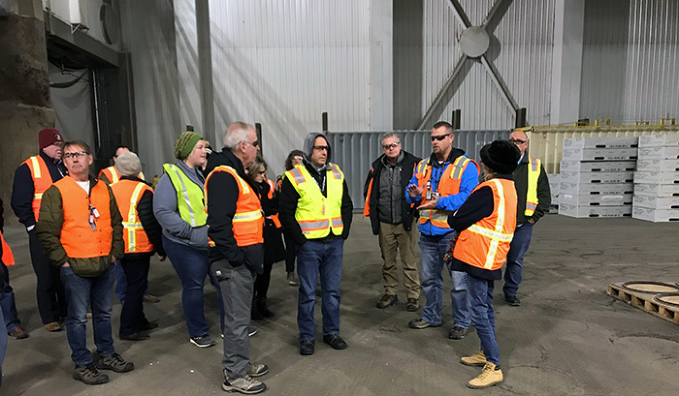 Nate Loftus with Fluor Idaho, EM’s Idaho National Laboratory Site contractor, addresses the EM Site-Specific Advisory Board Chairs inside the Transuranic Storage Area/Retrieval Enclosure, where thousands of waste drums await shipment to EM’s Waste Isolati