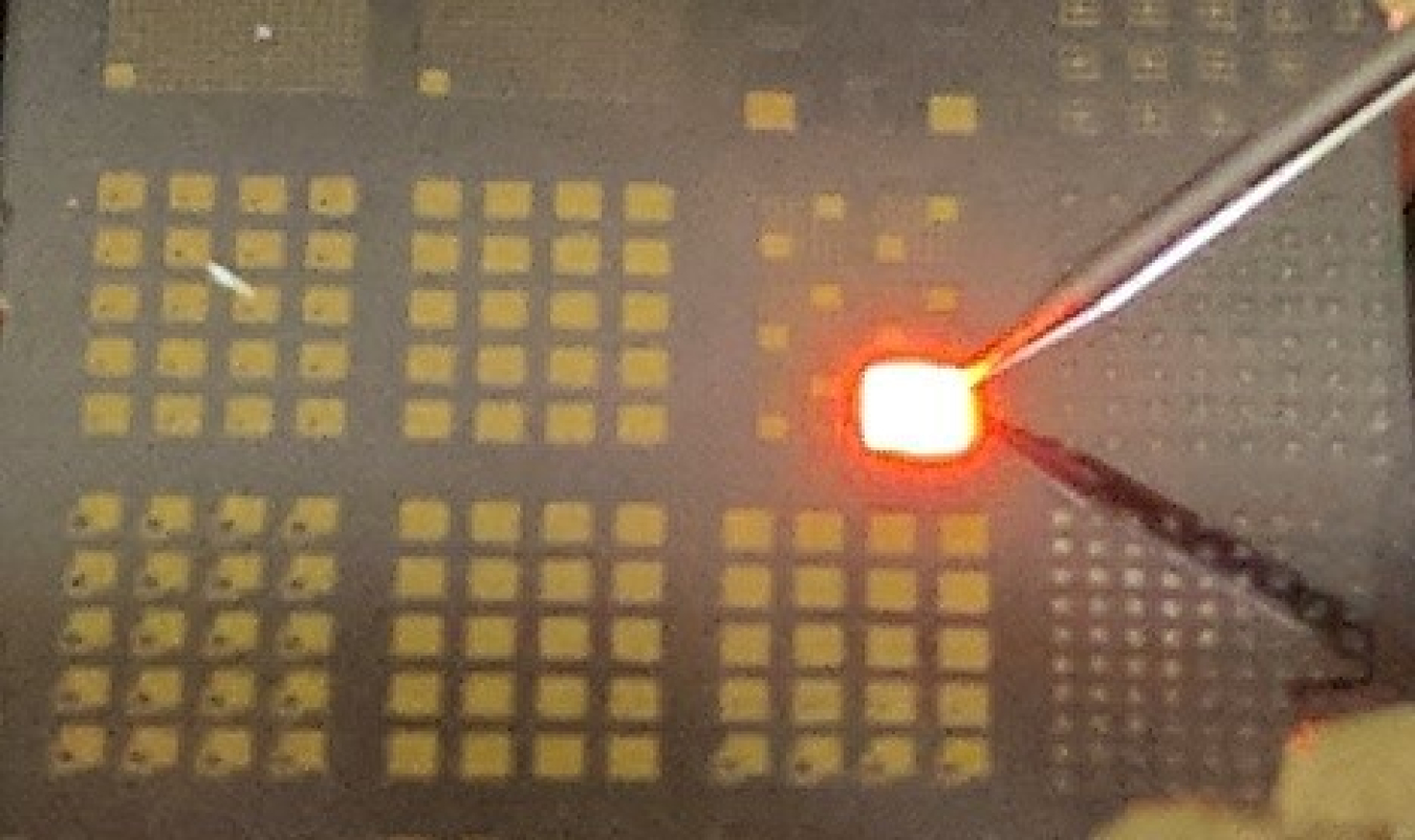 Photo showing light emission from an unpackaged AlInP LED on a substrate.