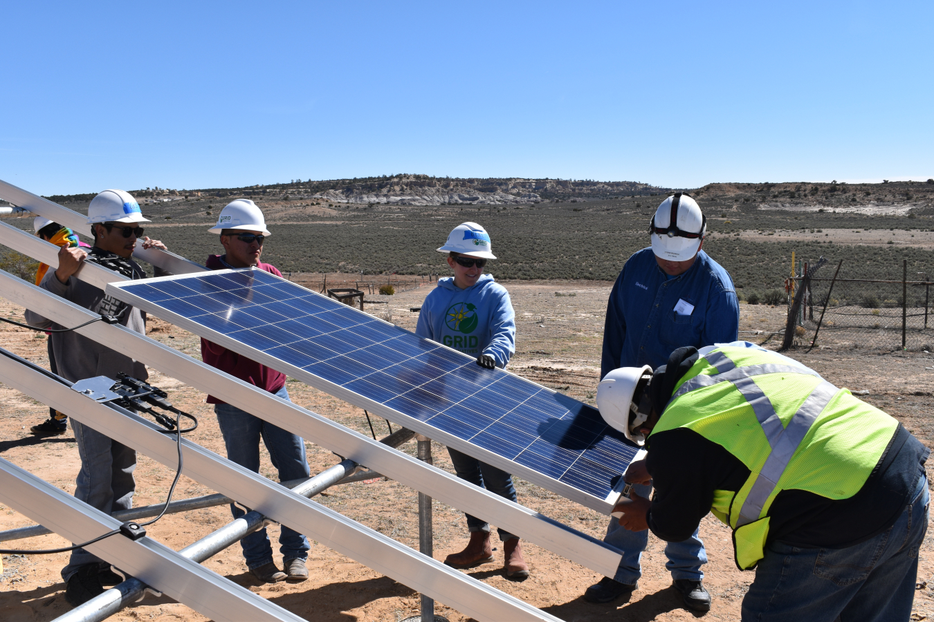 Trainees install a solar panel on a ground-mounted array at the Navajo Technical University in Ojo Encino, New Mexico. 