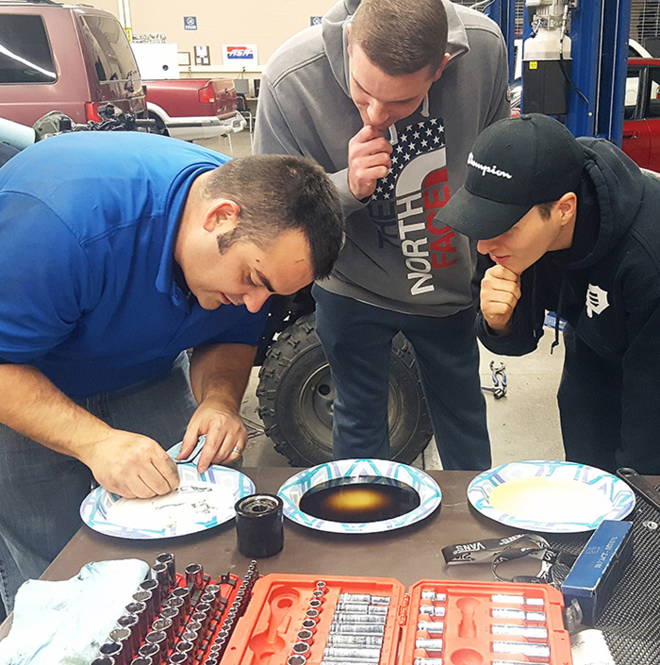 Steven Kirschenmann, left, a training specialist, demonstrates lubrication principles of oil-based lubricants to Columbia Basin College (CBC) students James Longmire, center, and Austin Silveira during a hydraulic and fluid flows class.