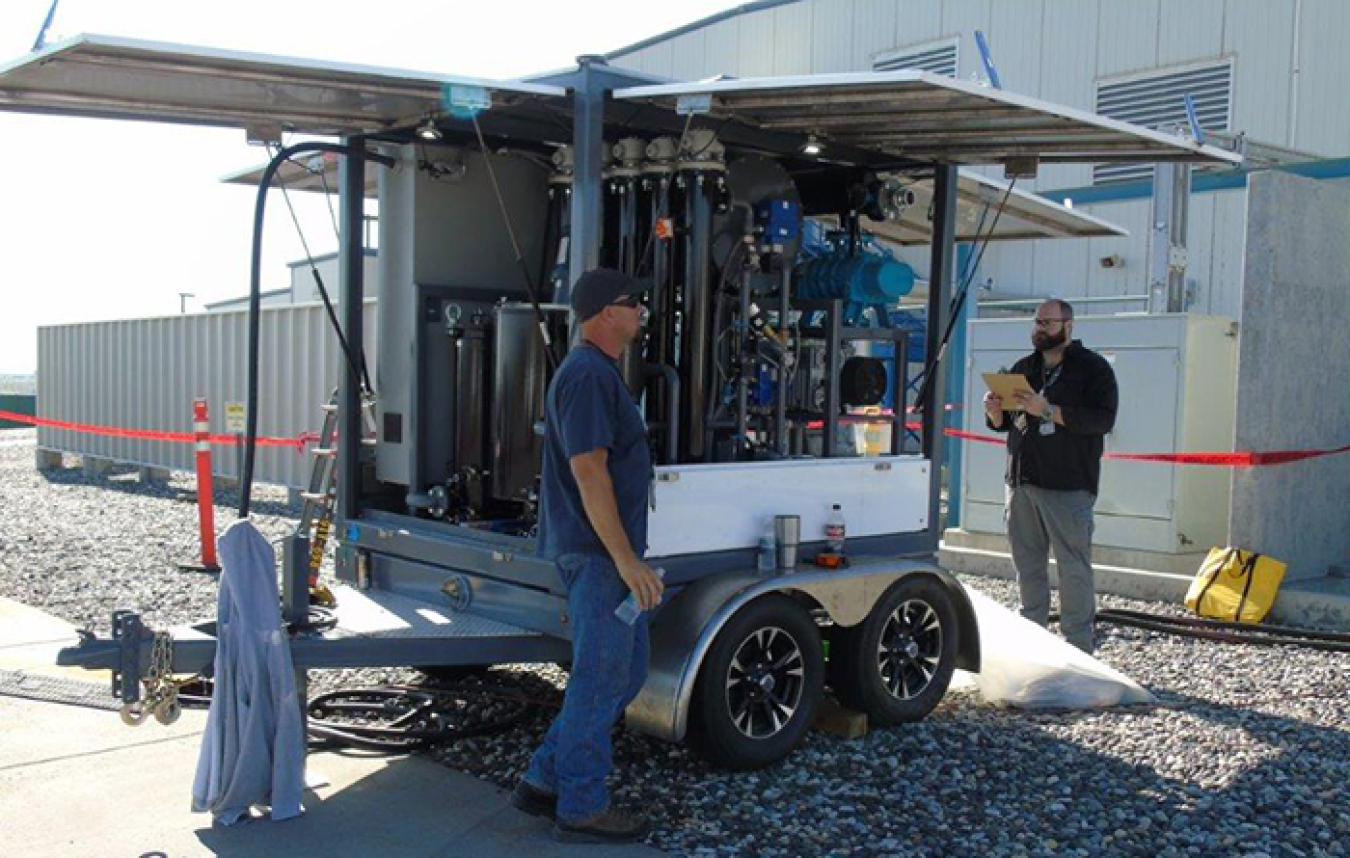 Mission Support Alliance substation electrician Matthew Starkey, left, and environmental compliance officer Mike Demiter perform oil reconditioning on a transformer in the 200 West Area.