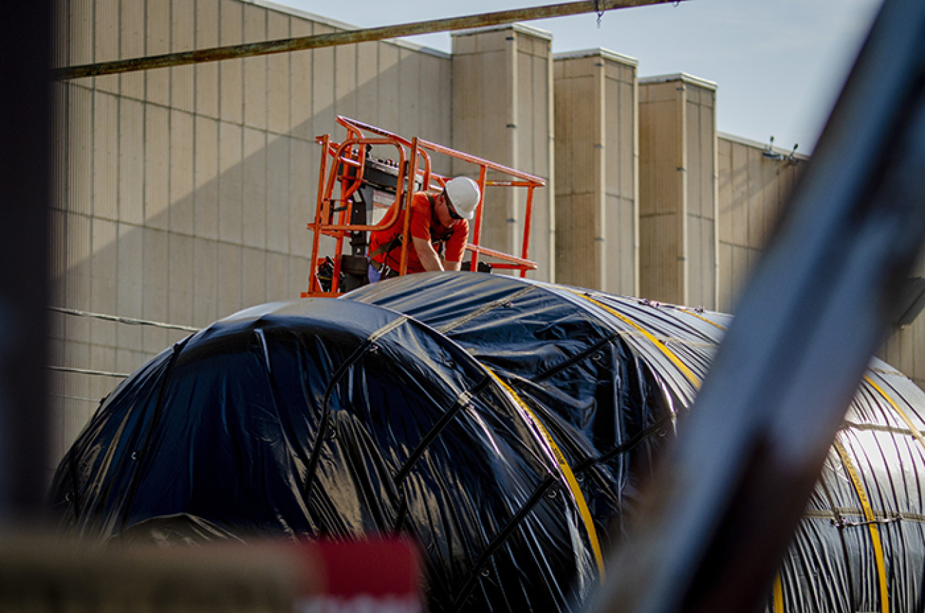 A deactivation worker with Four Rivers Nuclear Partnership helps secure a component from the Paducah Gaseous Diffusion Plant to a trailer to be shipped off-site.