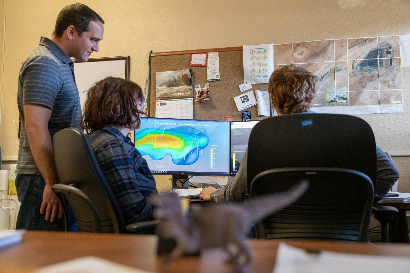 Photo of staff looking at a visualization on computer screen
