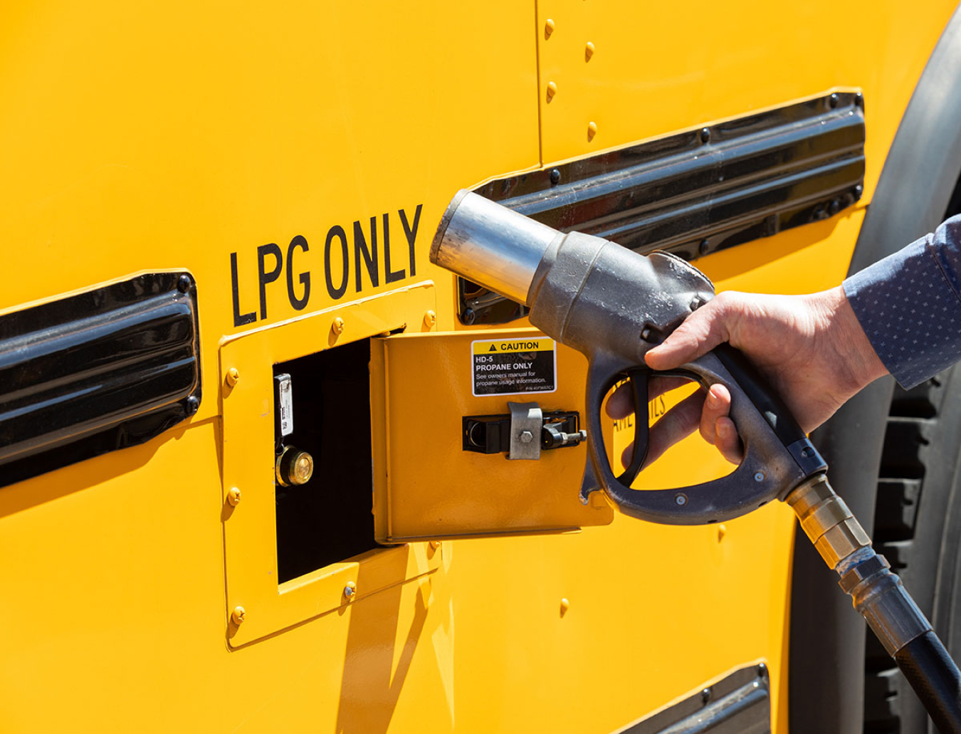 Person fueling a propane powered school bus.