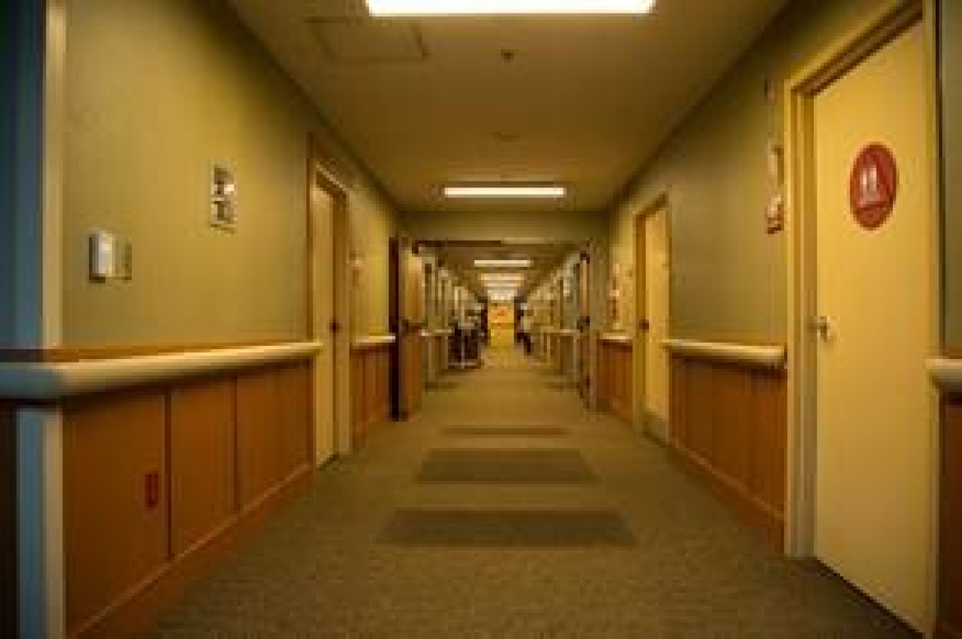 A nursing-care center hallway at night, with lighting dimmed to 20% output.