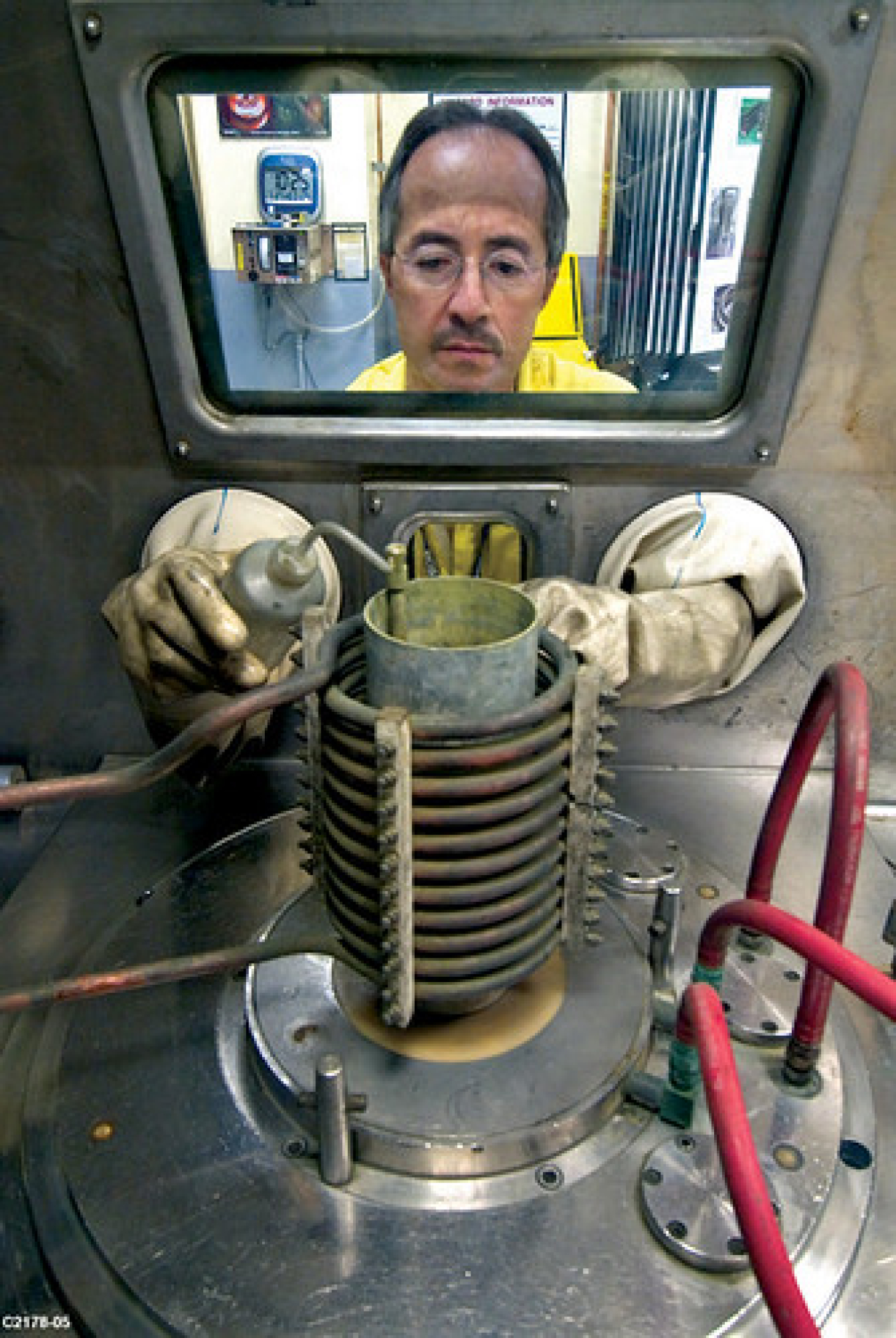 An employee at Los Alamos National Laboratory prepares to cast plutonium.