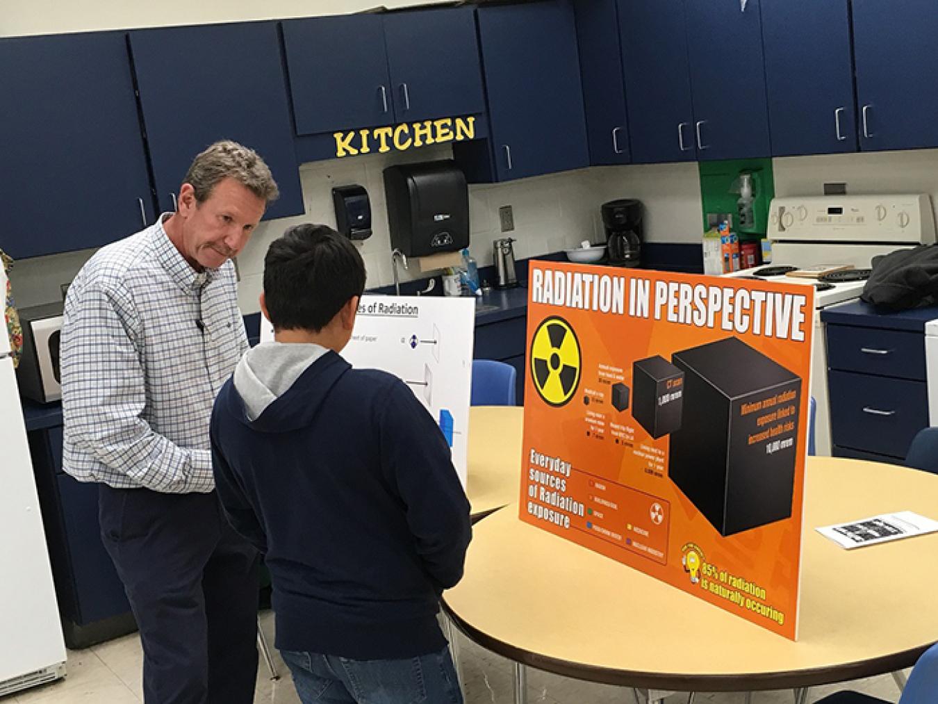 Joe Biggerstaff, a radiological protection integration and technical manager with UCOR, provides information about the sources of radiation to an attendee at the STEM event.