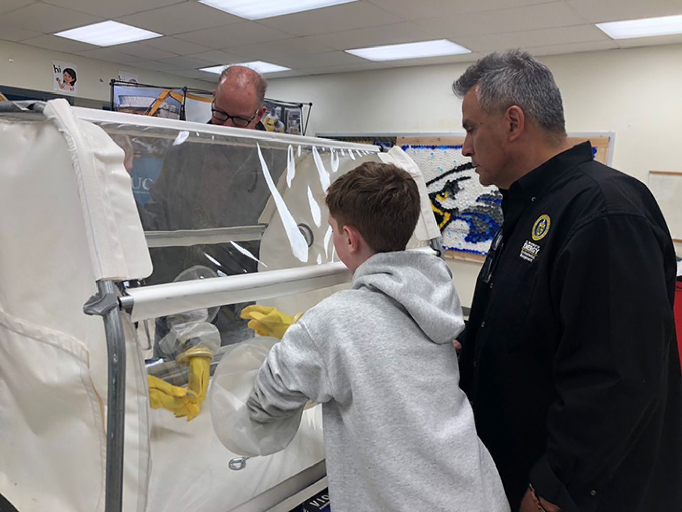 James Nunz, project management branch chief for Oak Ridge’s EM program, teaches students how to use a glovebox during a demonstration at the STEM event.