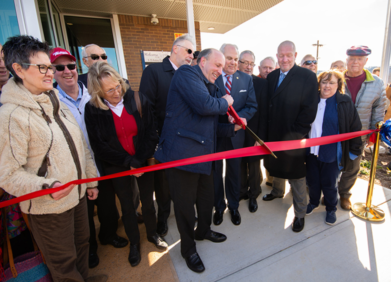 Holding an oversized pair of scissors, DOE Under Secretary for Science Paul Dabbar and Oak Ridge Mayor Warren Gooch cut a ceremonial ribbon to mark the grand opening of the K-25 History Center. 