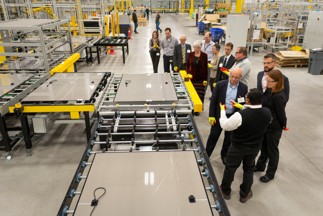 First Solar Senior Vice President, Strategic Sourcing & Global Supply Chain, Jigish Trivedi (bottom right) shows Assistant Secretary Daniel R Simmons and Solar Energy Technologies Office Director Becca Jones-Albertus nearly finished photovoltaic modules.