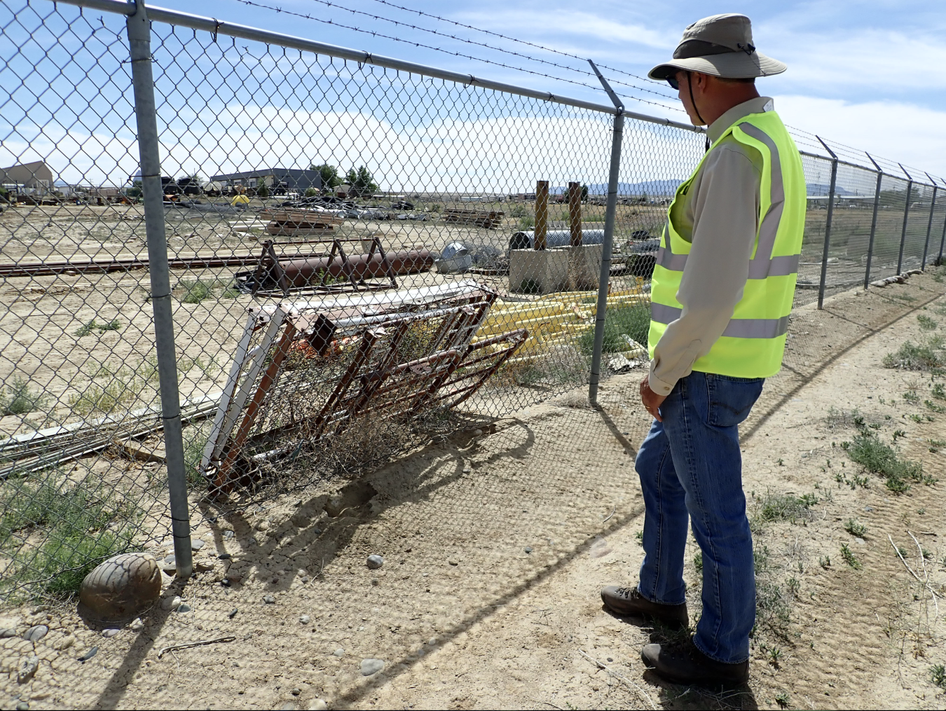 LM worker checks fence post on project at site.