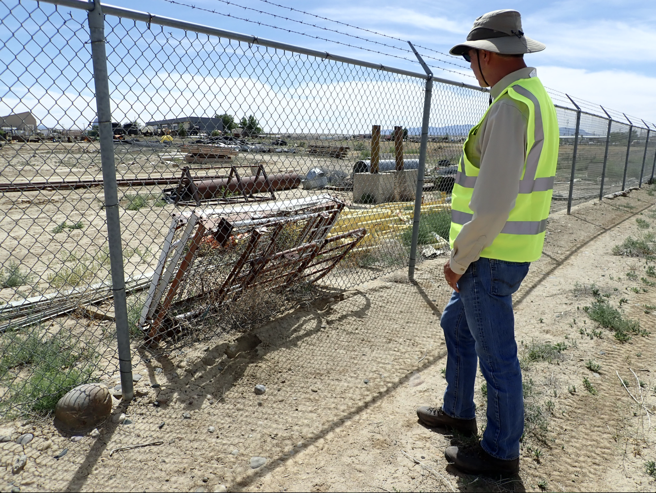 LM worker checks fence post on project at site. 