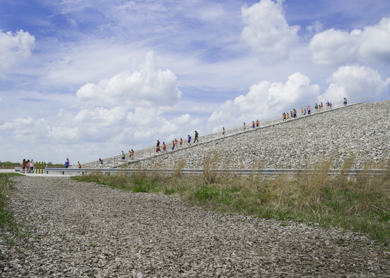 Students hike the stairs on the Weldon Spring Site Disposal Cell surrounded by Howell Prairie