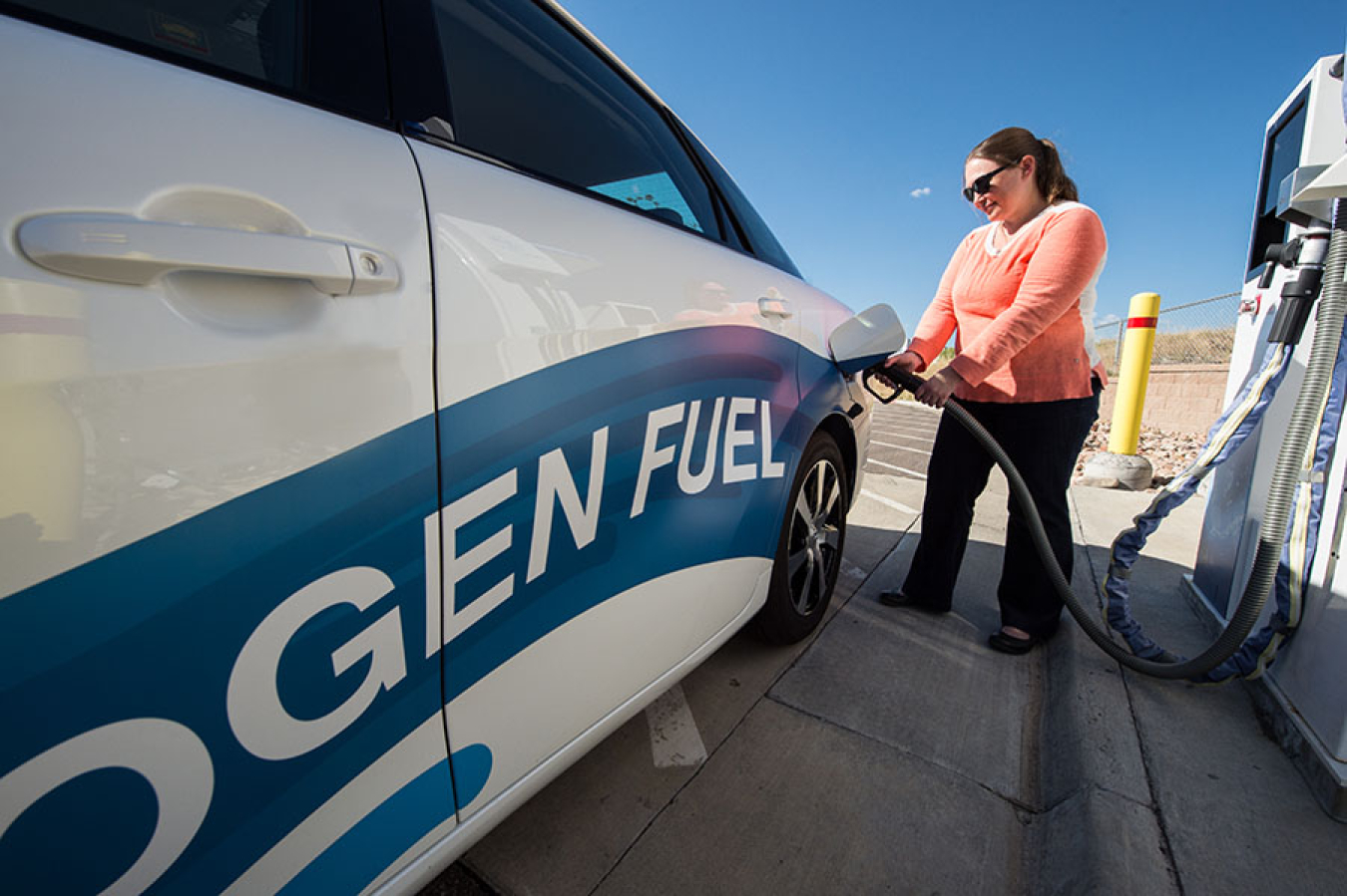 Woman filling up a hydrogen fuel vehicle.