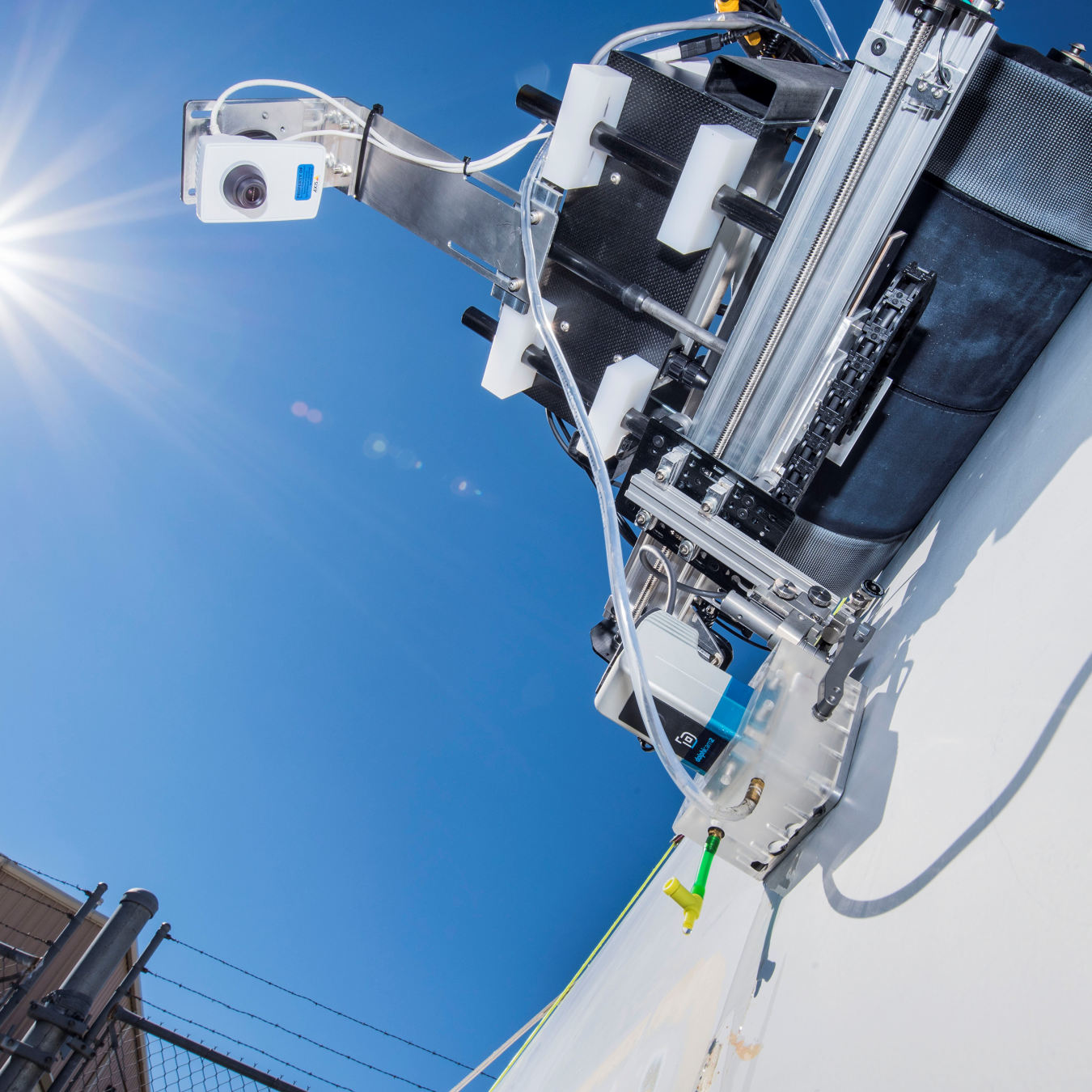 Photo of a crawling robot against a clear blue sky.