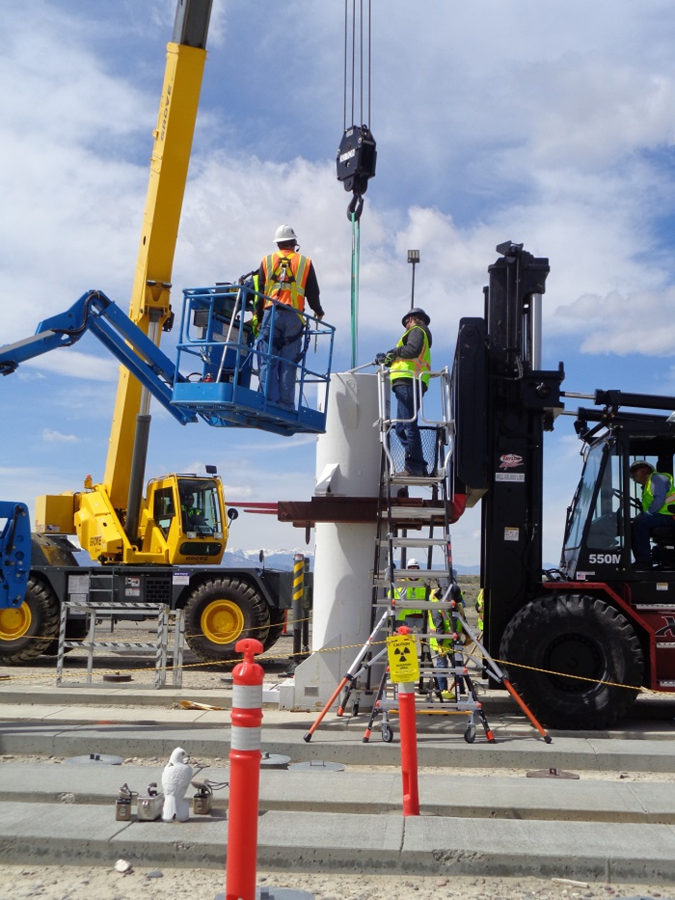 EM workers use a crane to lower a canister filled with spent nuclear fuel into a liner inside the Radioactive Scrap and Waste Facility at the Idaho National Laboratory Site.