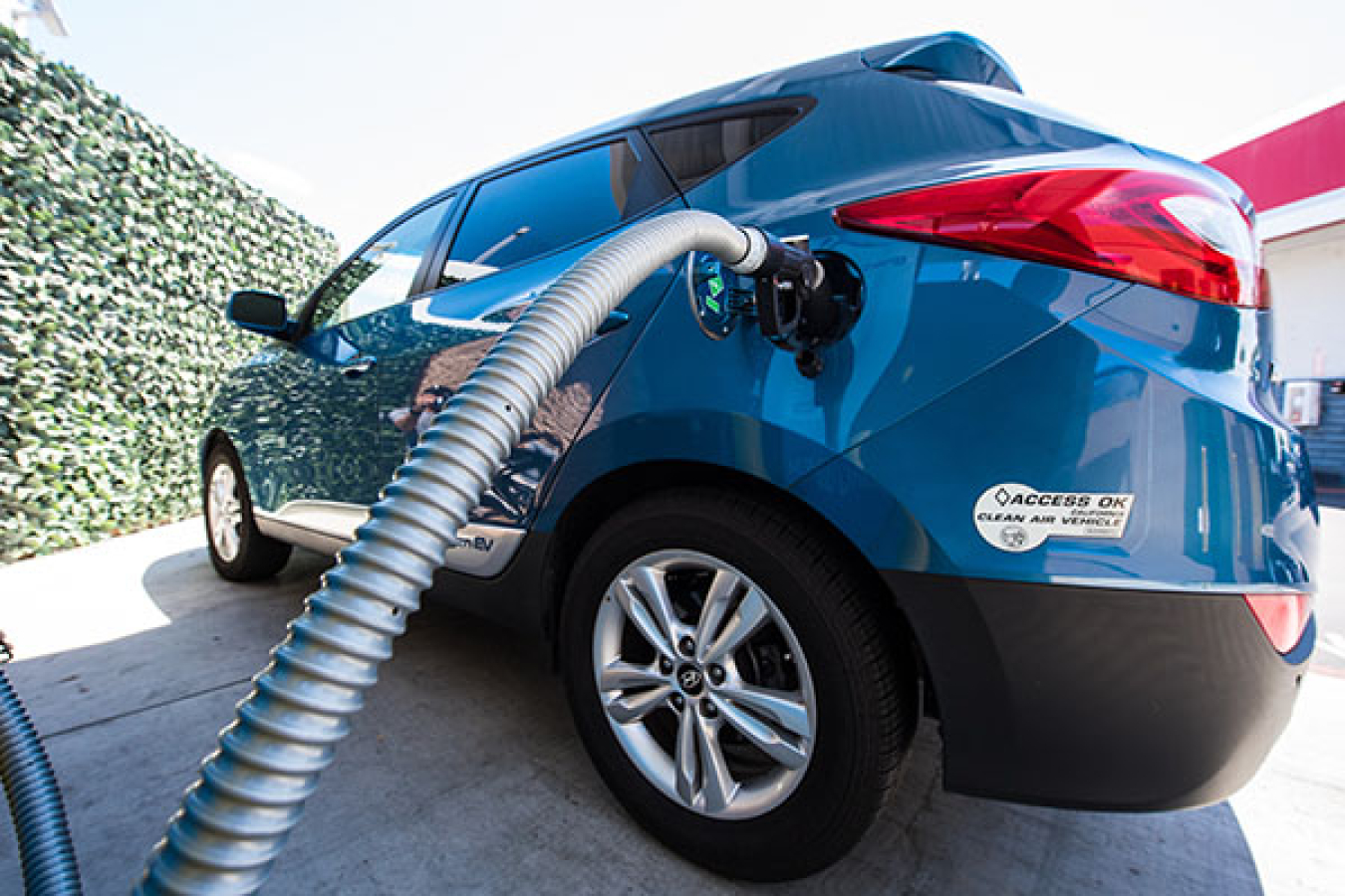 Blue vehicle being fueled.
