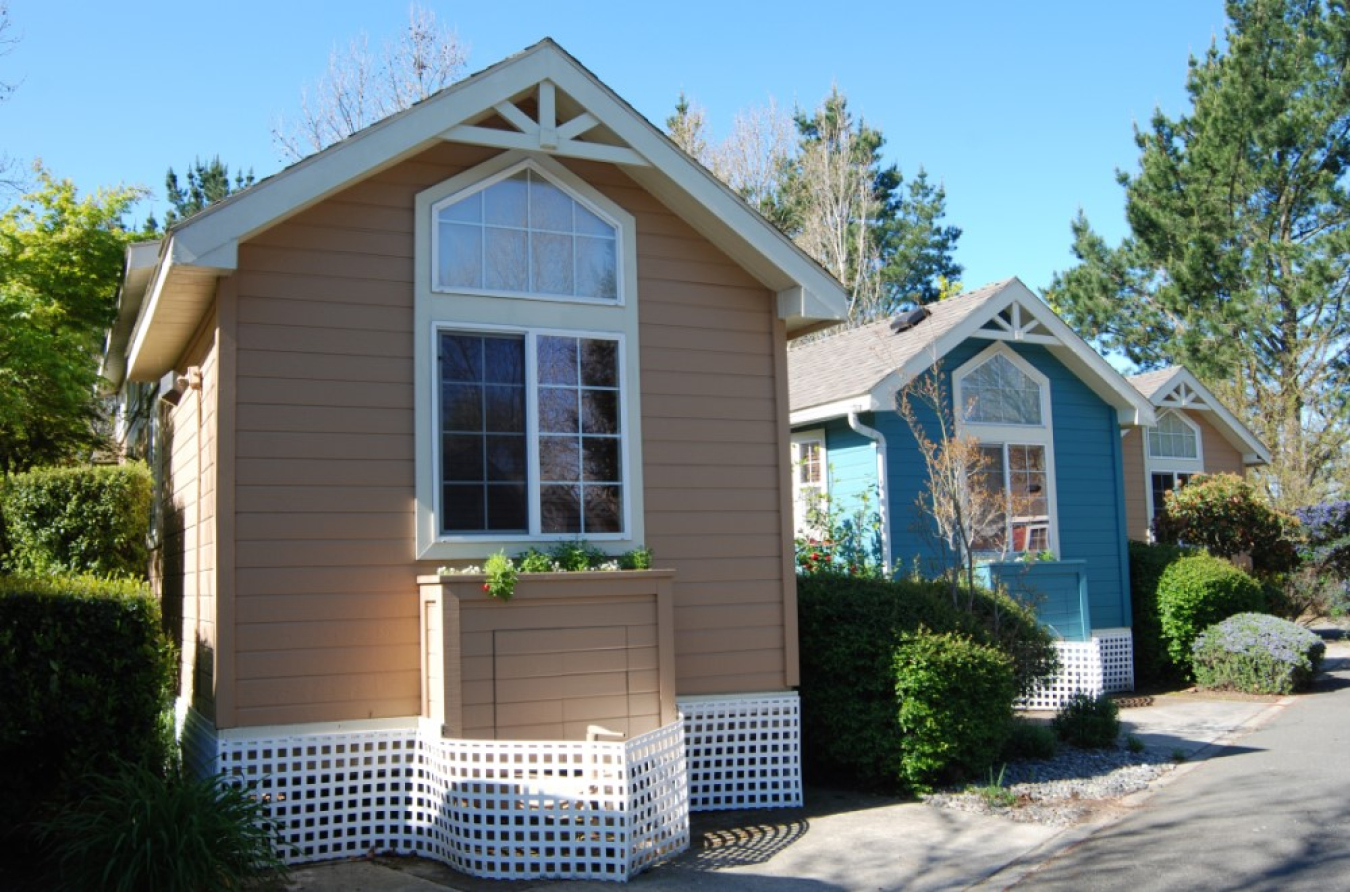 This is a photo of three small buildings with white trim around the windows.