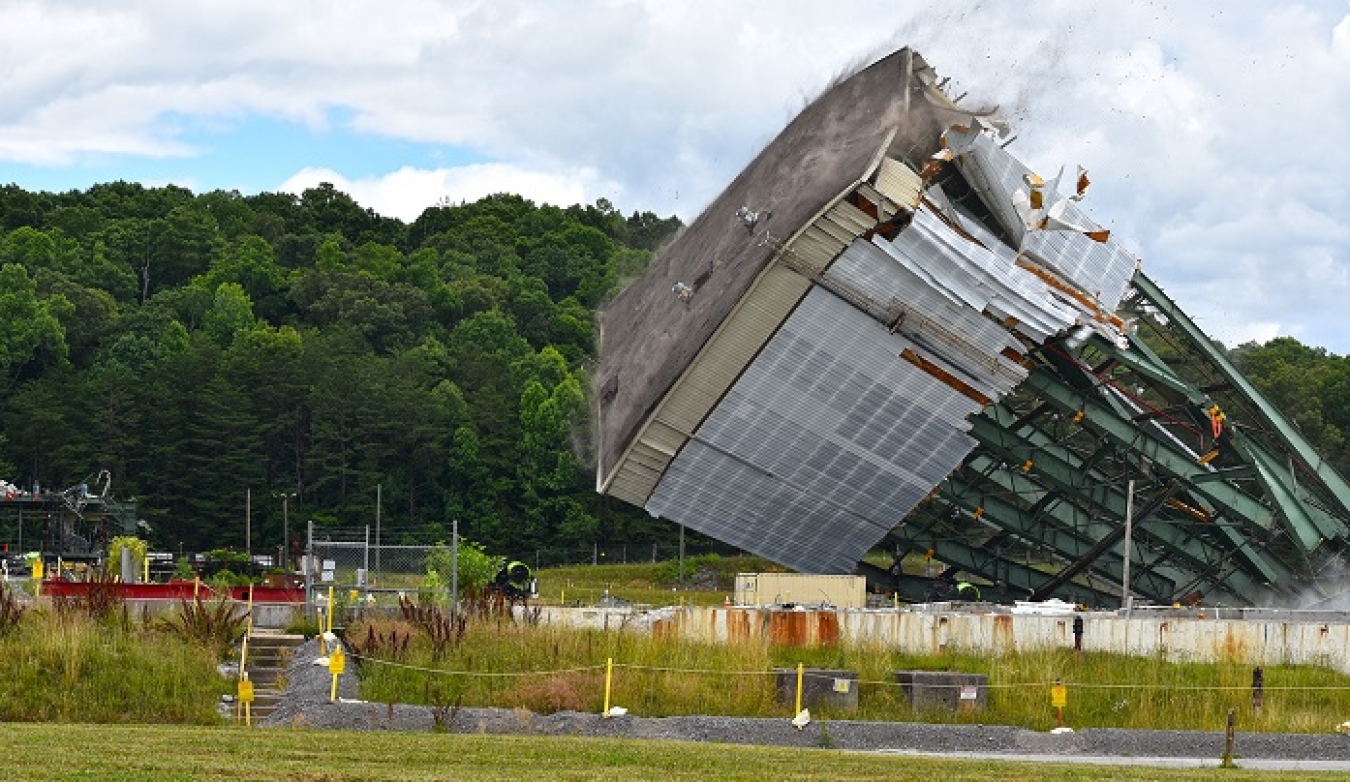 Crews use large winches to tear down a 180-foot tower of the Centrifuge Complex at Oak Ridge.