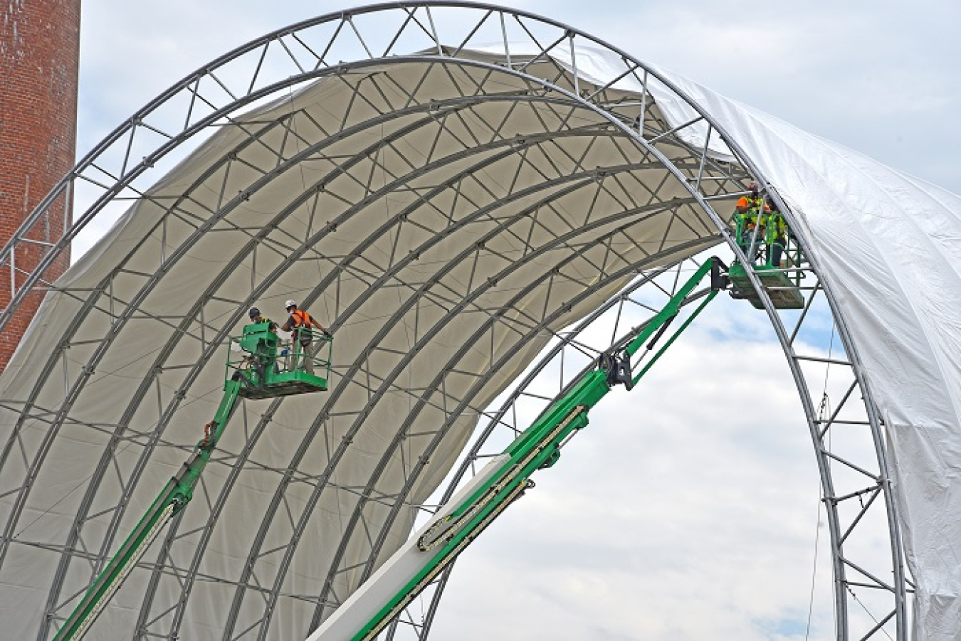 Crews are manually adding 12,000 square feet of fabric to the trusses to complete the cover for the protective tent at the Building 3026 demolition project at Oak Ridge.