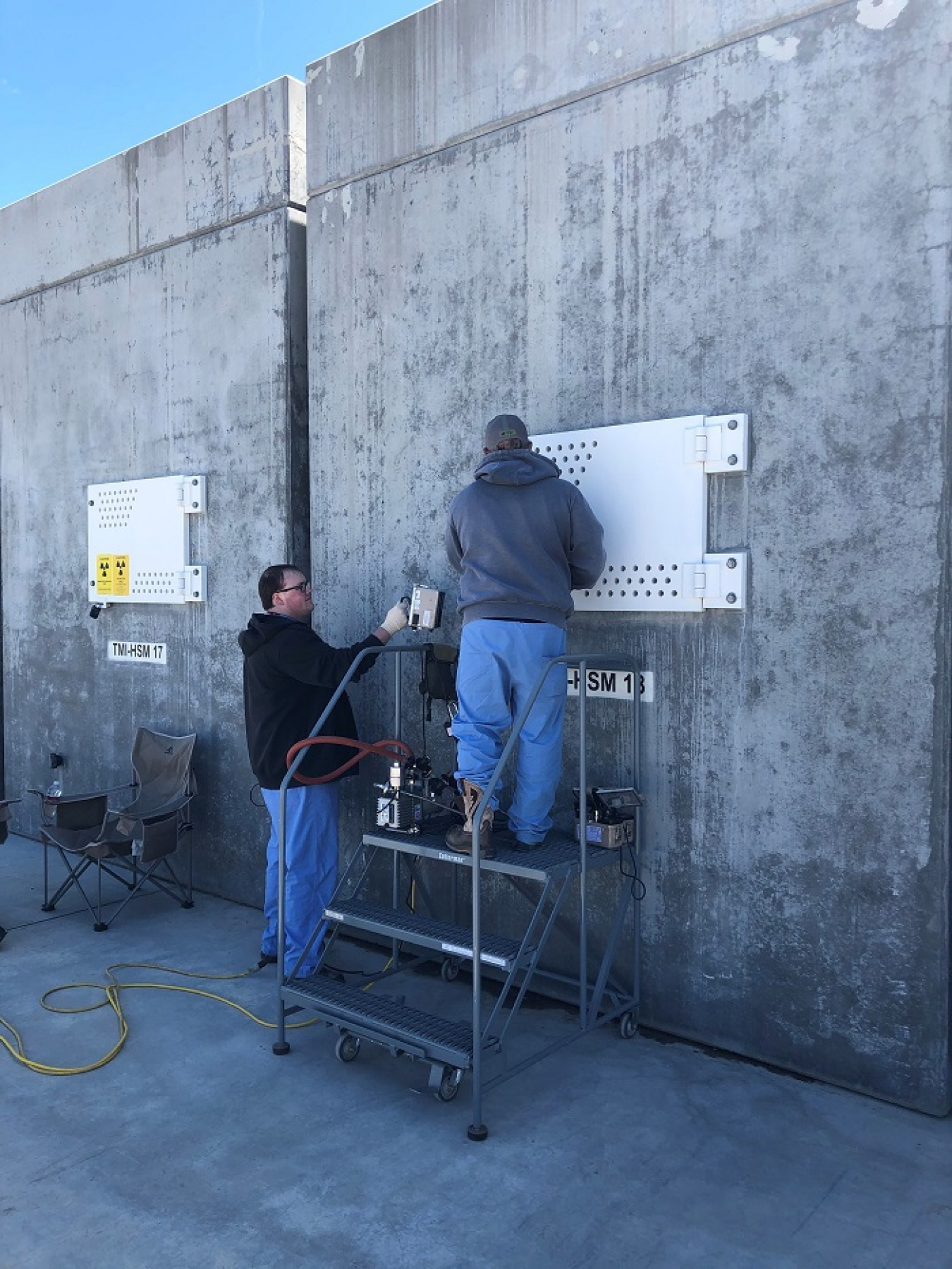 Fluor Idaho Fuel Handling Operator Tyler Lane, right, and Senior Radiological Control Technician Tristan Shurtliff conduct a leak test on a storage vault containing Three Mile Island Unit 2 spent nuclear fuel and debris at the Idaho National Laboratory.