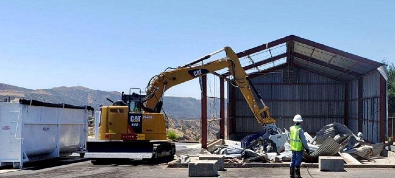 A crew tears down an equipment storage building at the Radioactive Materials Handling Facility complex at the Energy Technology Engineering Center.