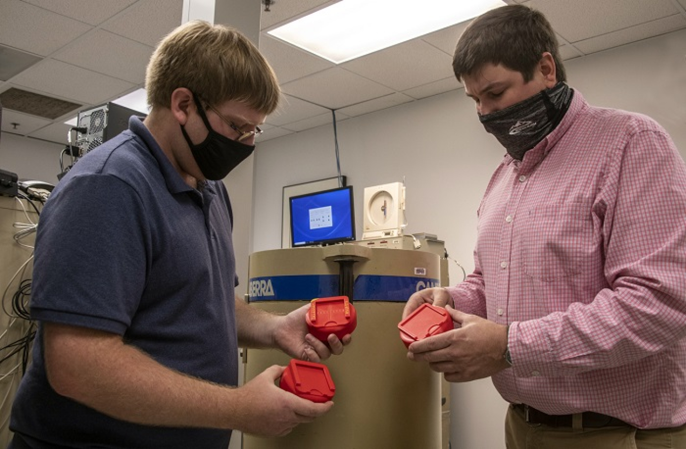 Savannah River Nuclear Solutions (SRNS) Senior Health Physicist Michael Ratliff, left, examines parts created by SRNS Principal Scientist Andy Warren using a 3D printer.