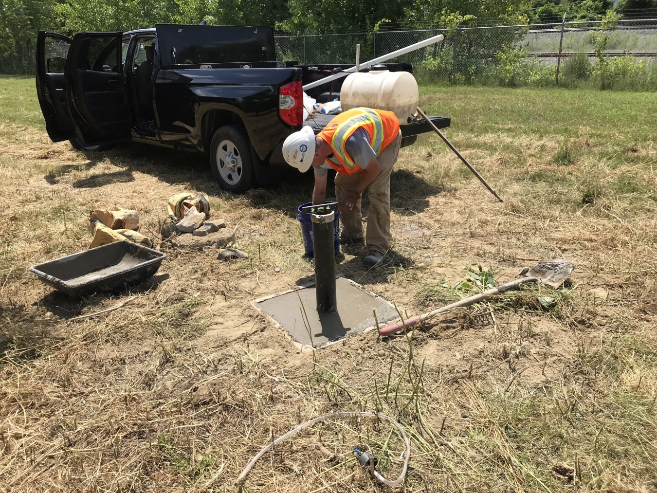 A worker repairs a damaged monitoring well at the Colonie site.