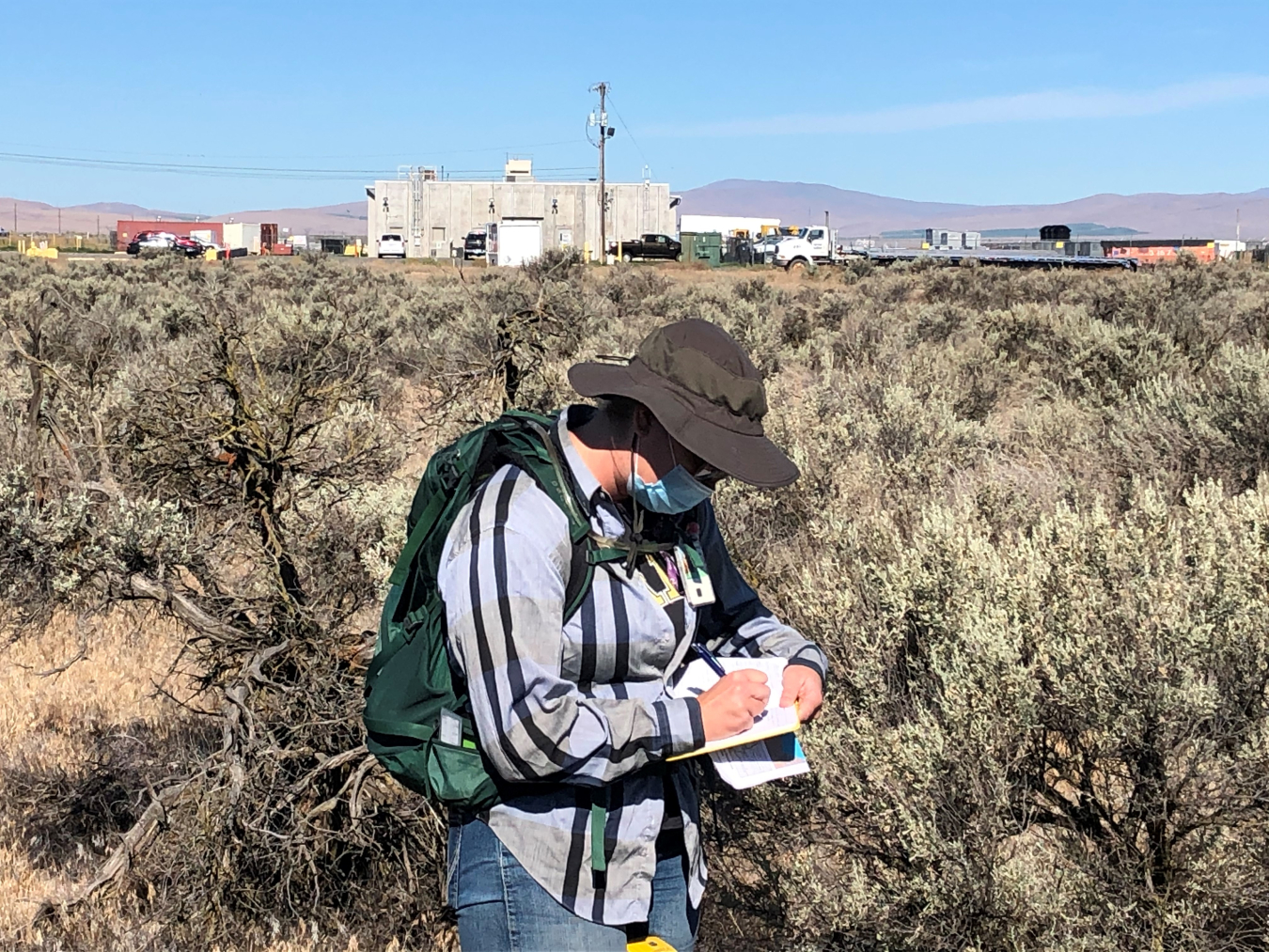 Archaeologist Lindsay Kiel with EM Richland Operations Office contractor Mission Support Alliance takes field notes during an archaeological survey on Hanford’s Central Plateau.