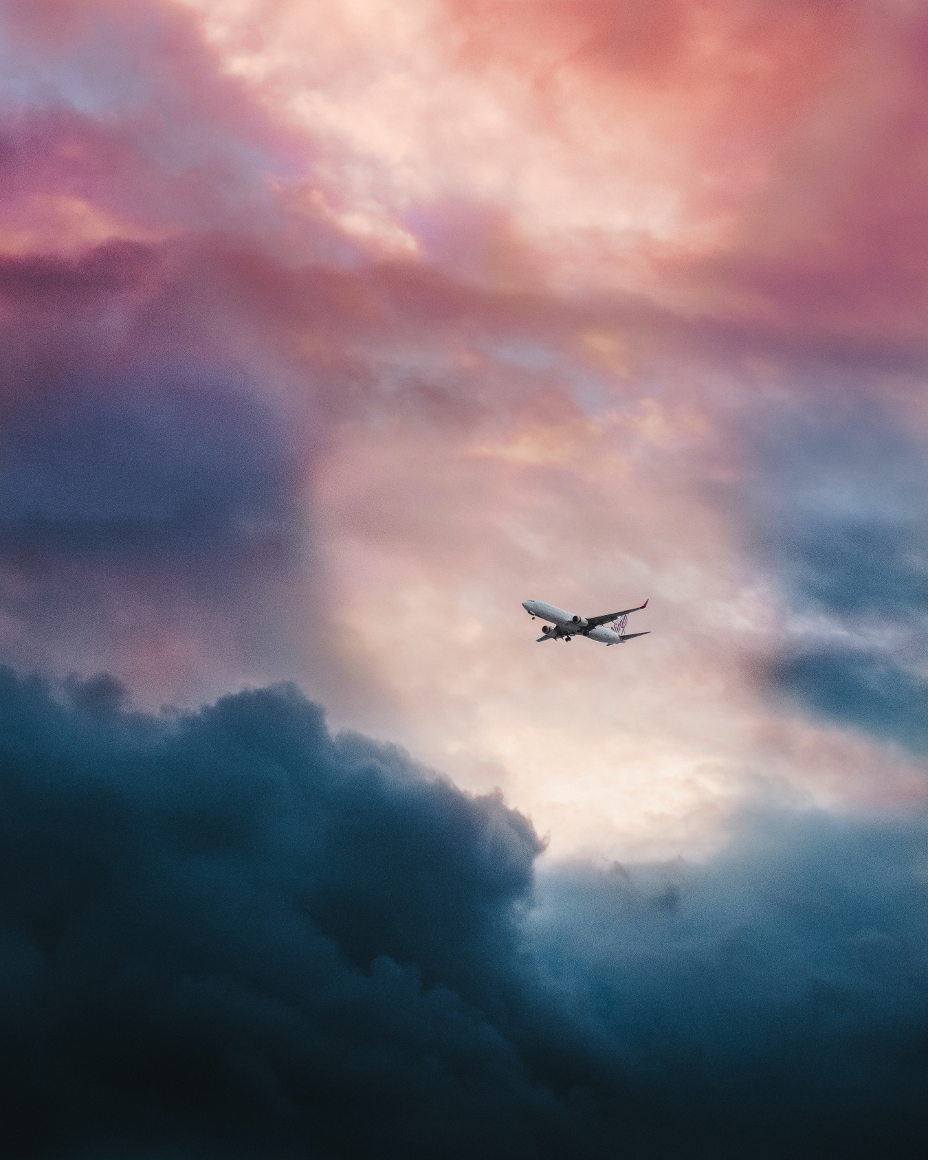 Commercial jet aircraft flying through clouds.