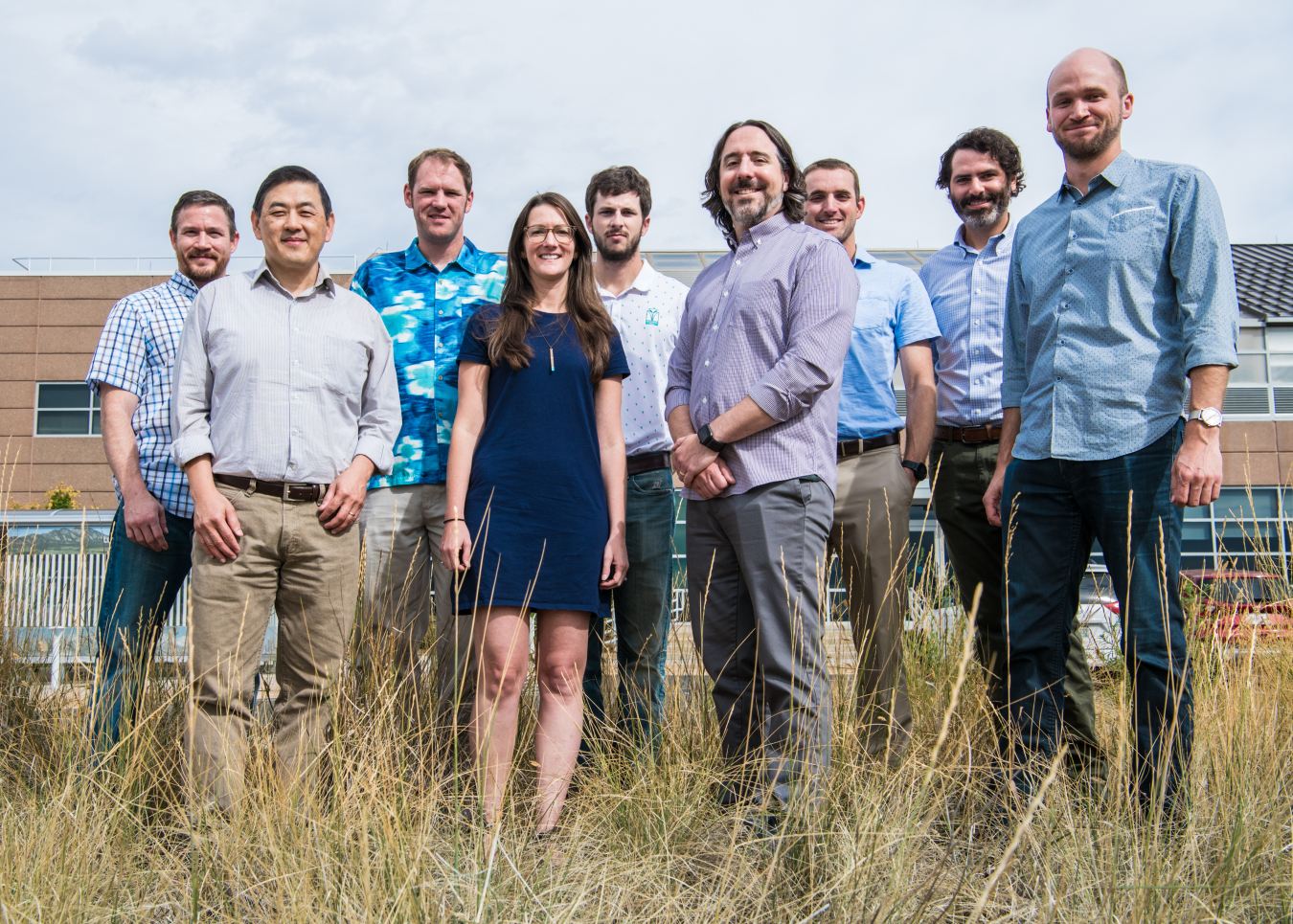 a group of 9 people standing in a field.